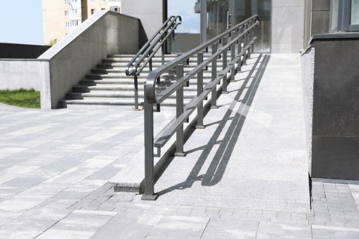 Exterior Marana building entrance with steps and ramp; stainless steel handrails.