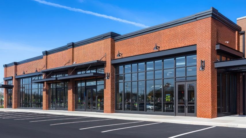 Brick retail building with black-framed windows and awnings