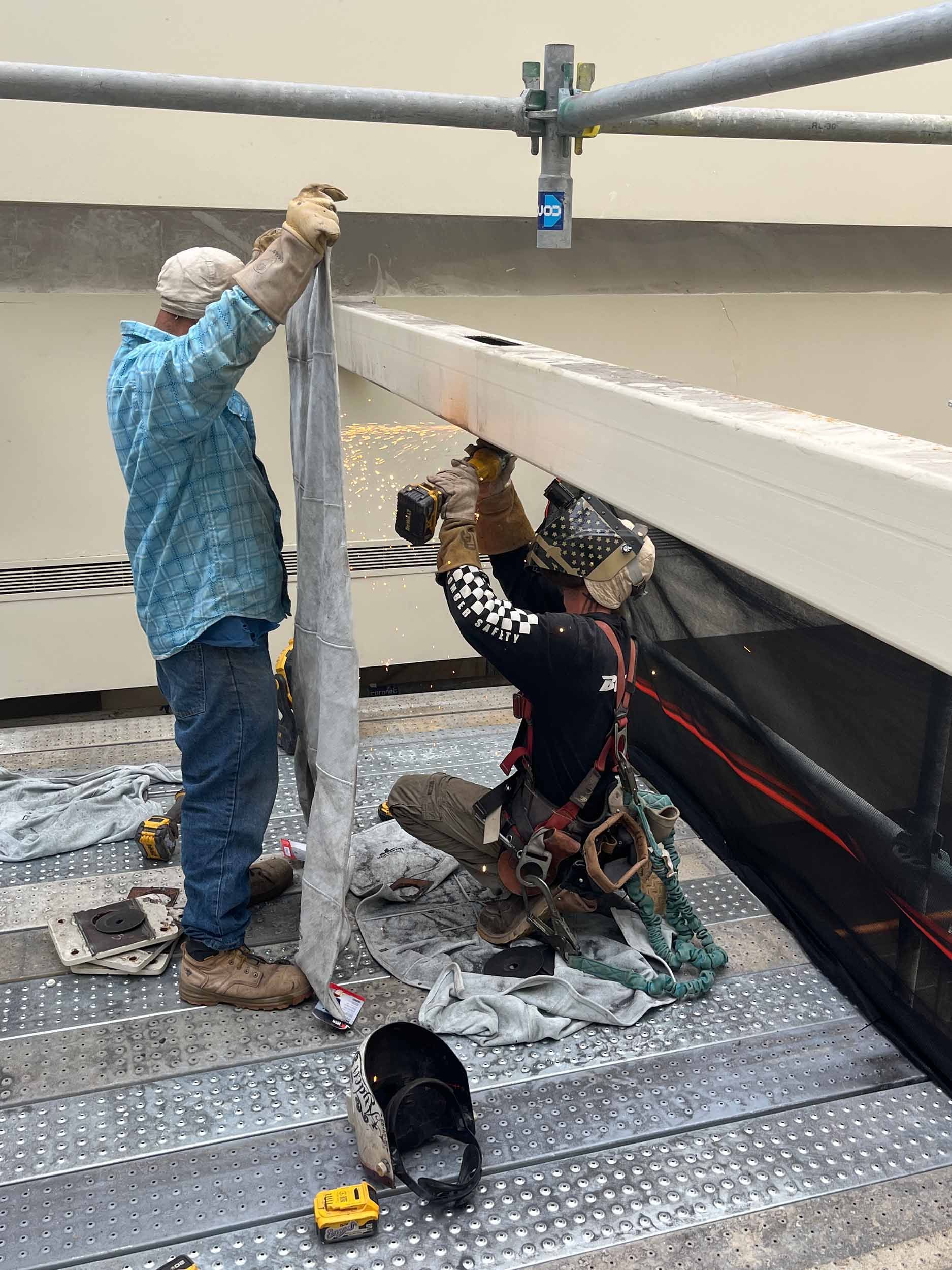 Welders working on scaffolding as sparks fly