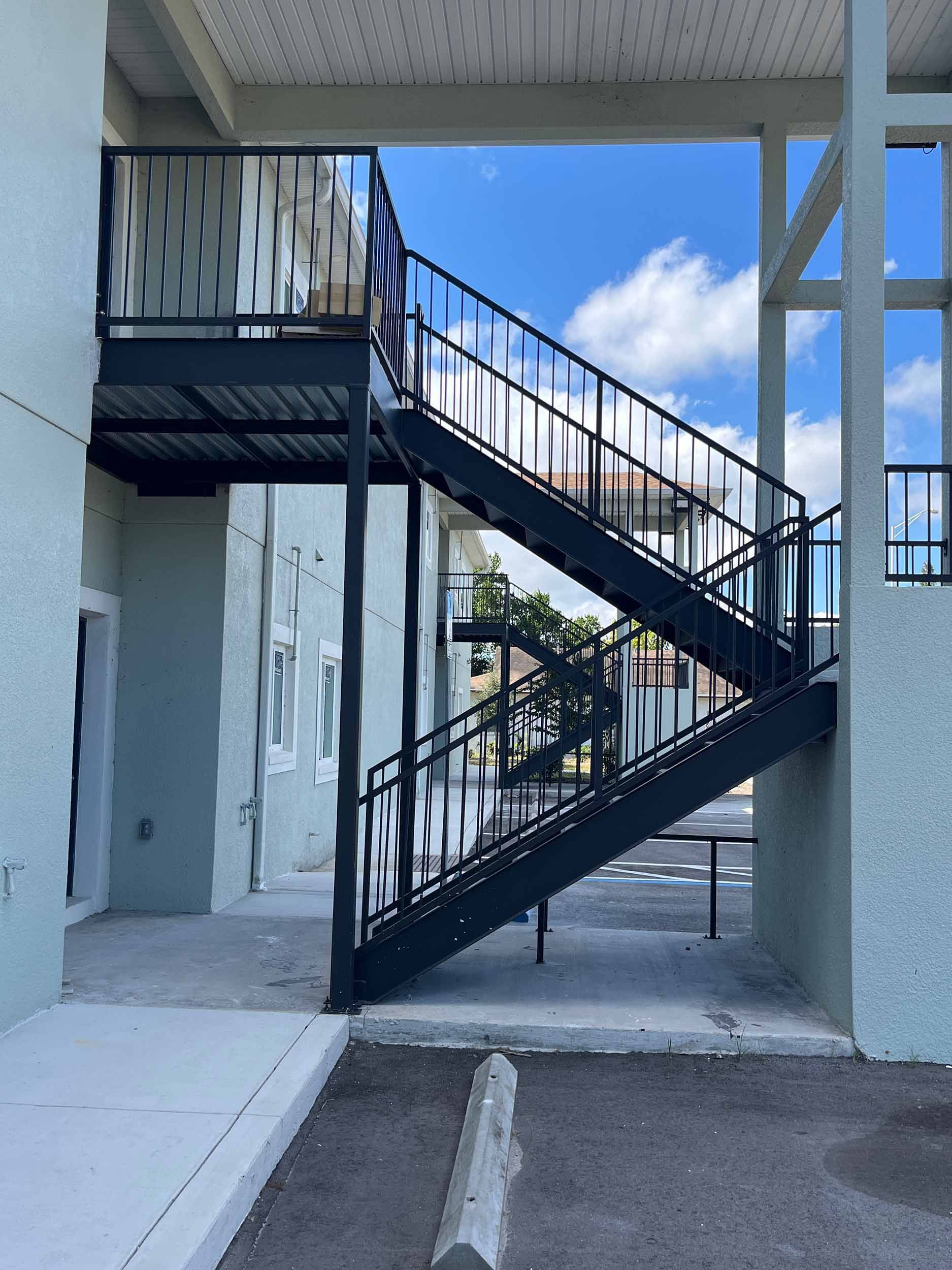 Exterior metal staircase against a light green building