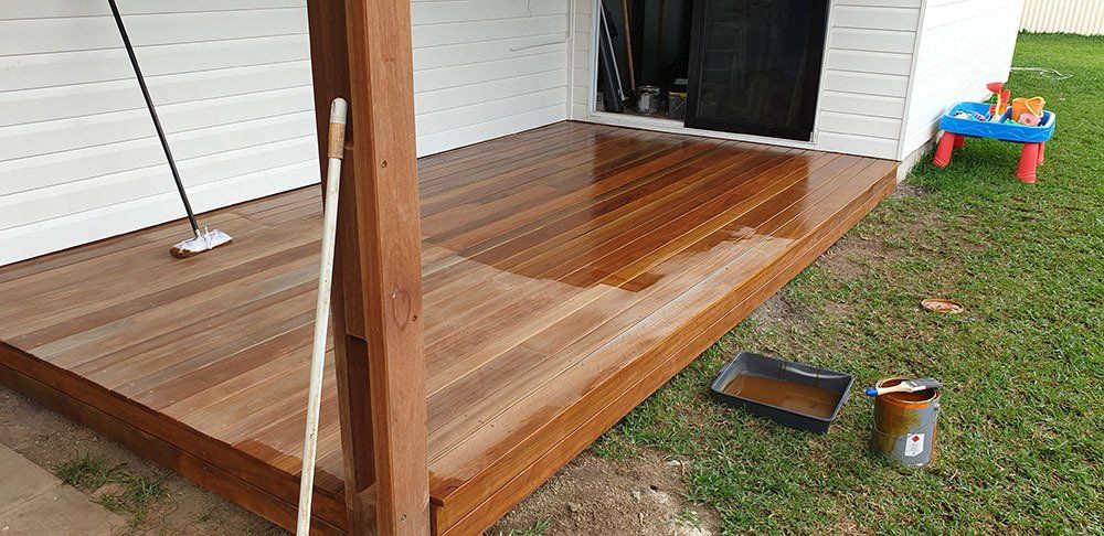 Closer View On Going Paint of Wooden Deck — Licensed Builders in Rockhampton, QLD