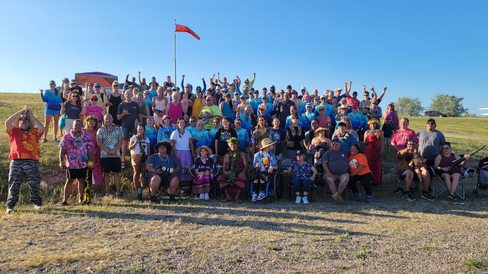 A large group of people are posing for a picture in a field.
