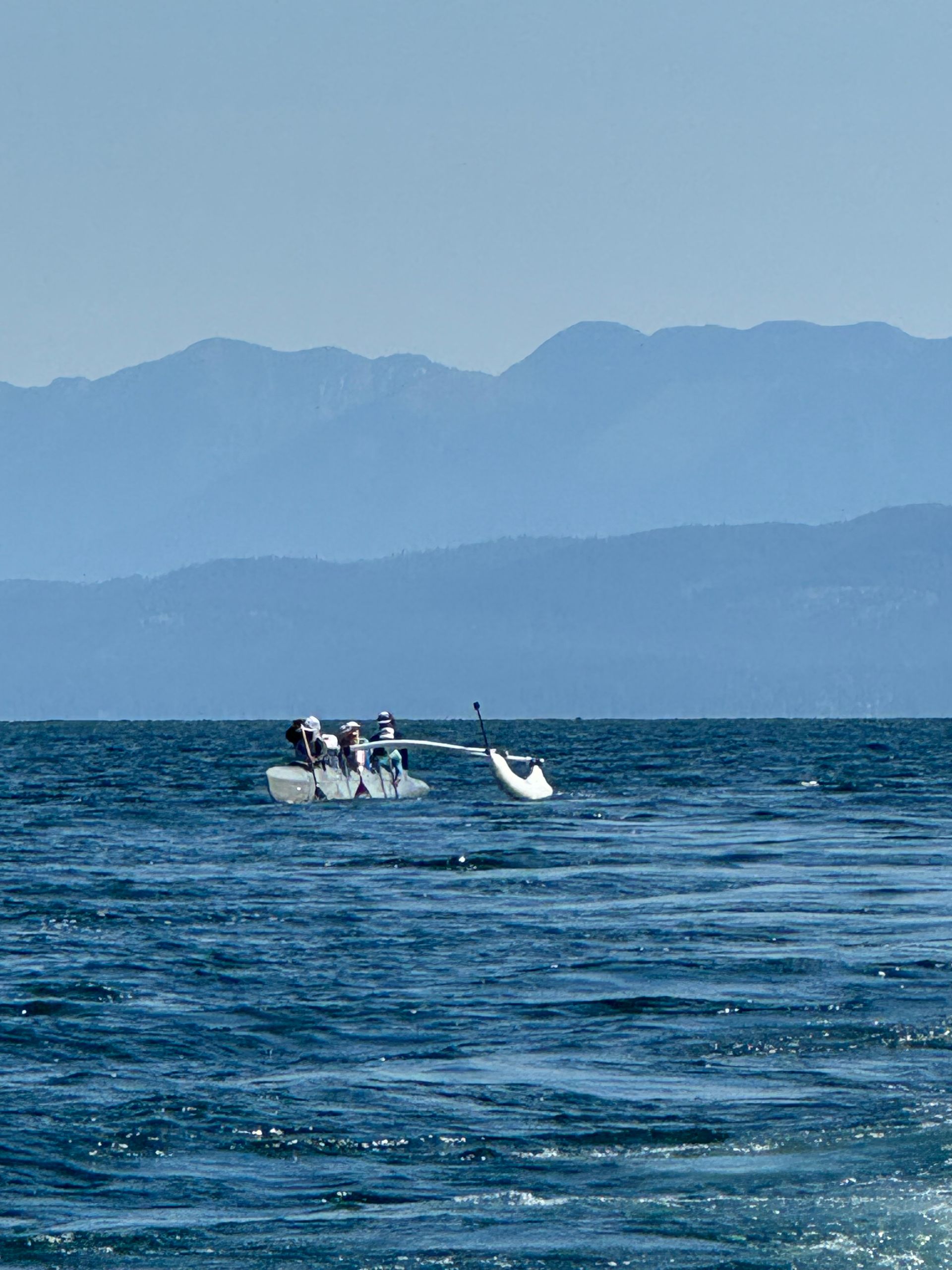 A boat in the ocean with mountains in the background