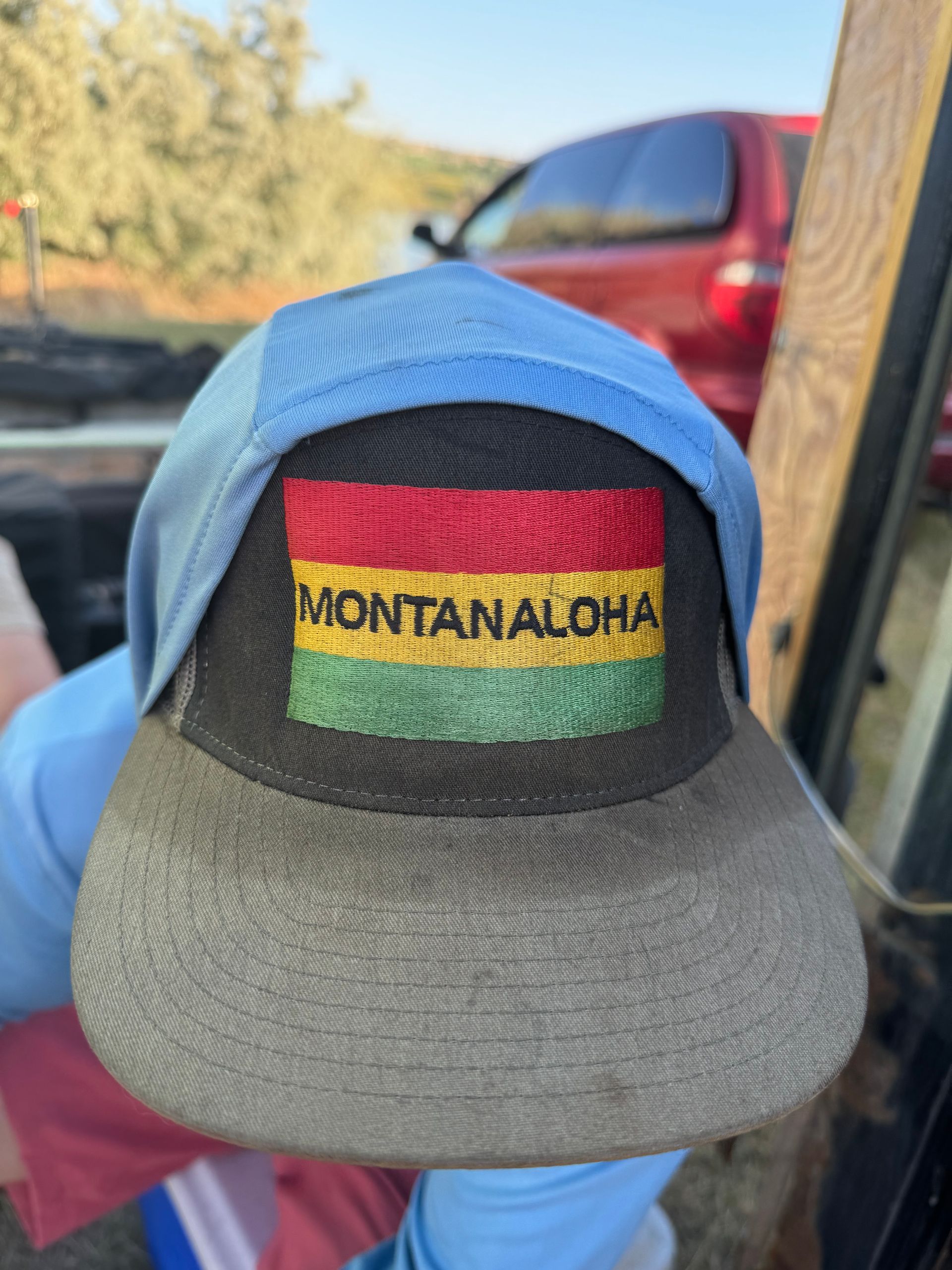 A person is holding a hat that says montana aloha on it
