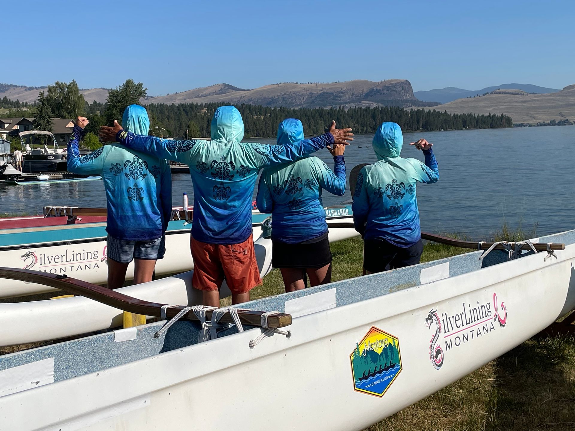 A group of people standing next to a boat that says montana on it