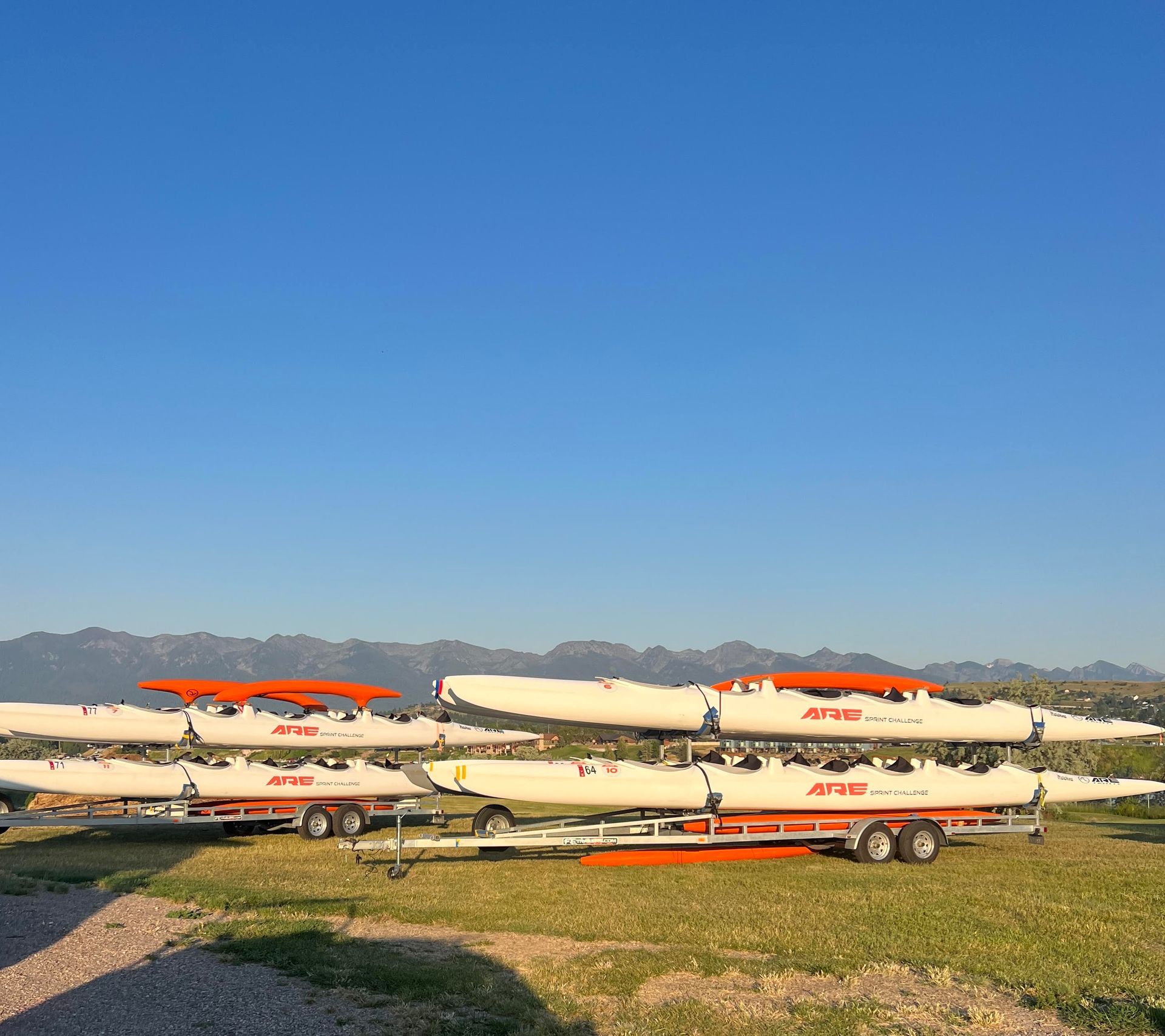 A group of people are sitting on a bench holding a snowboard in front of their faces.