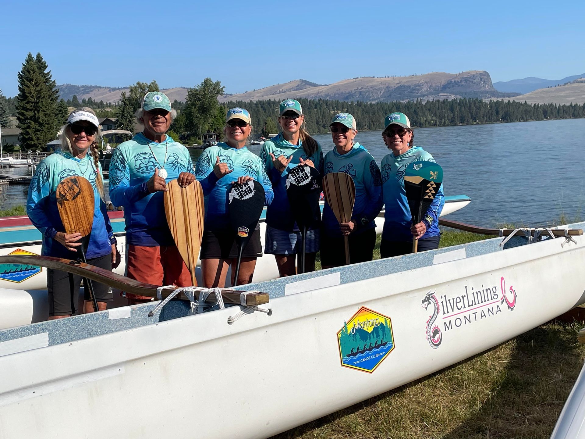 A group of people standing next to a boat that says ' jackson ' on it