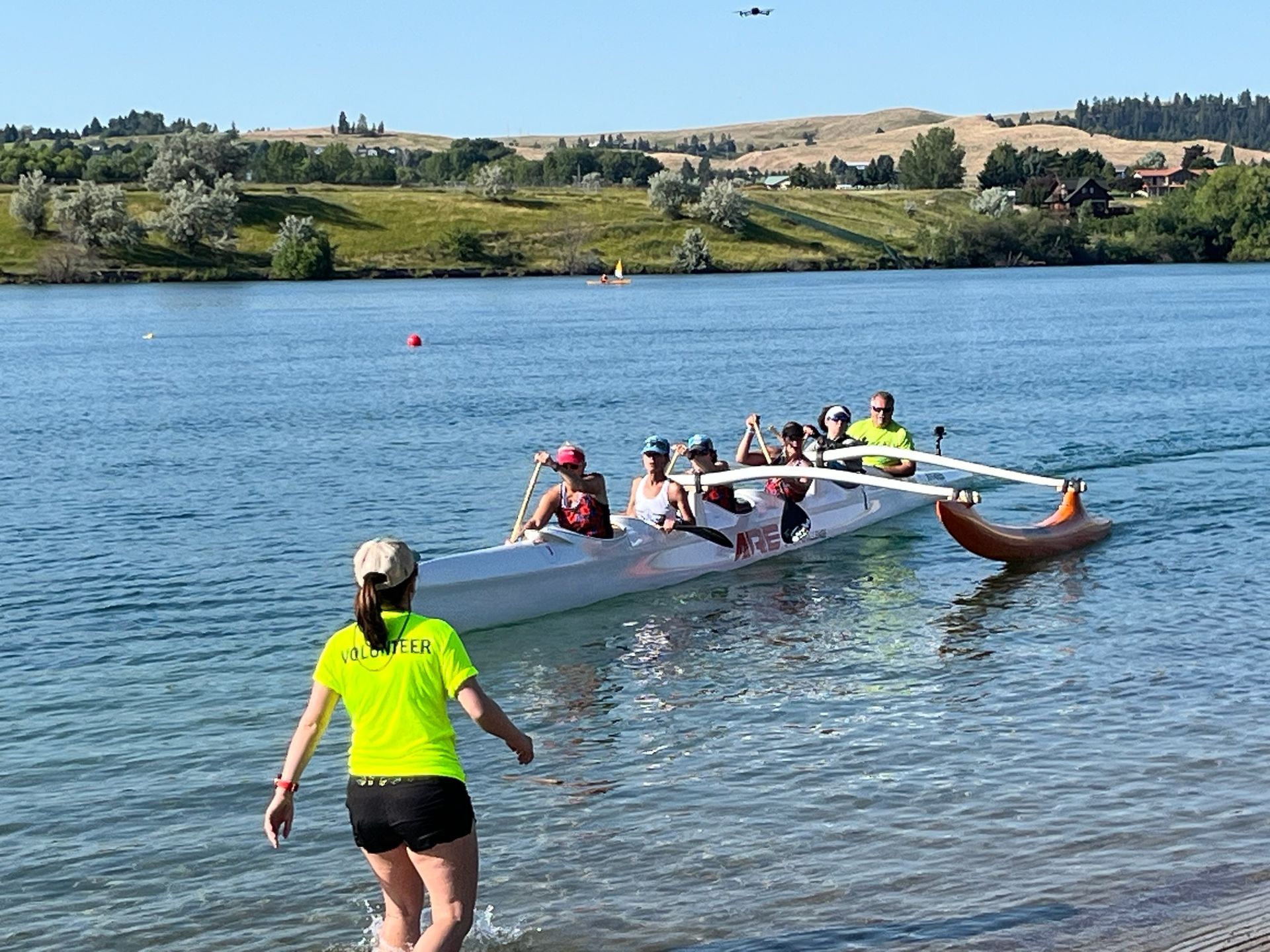 A man is standing next to a car with bags on the roof.