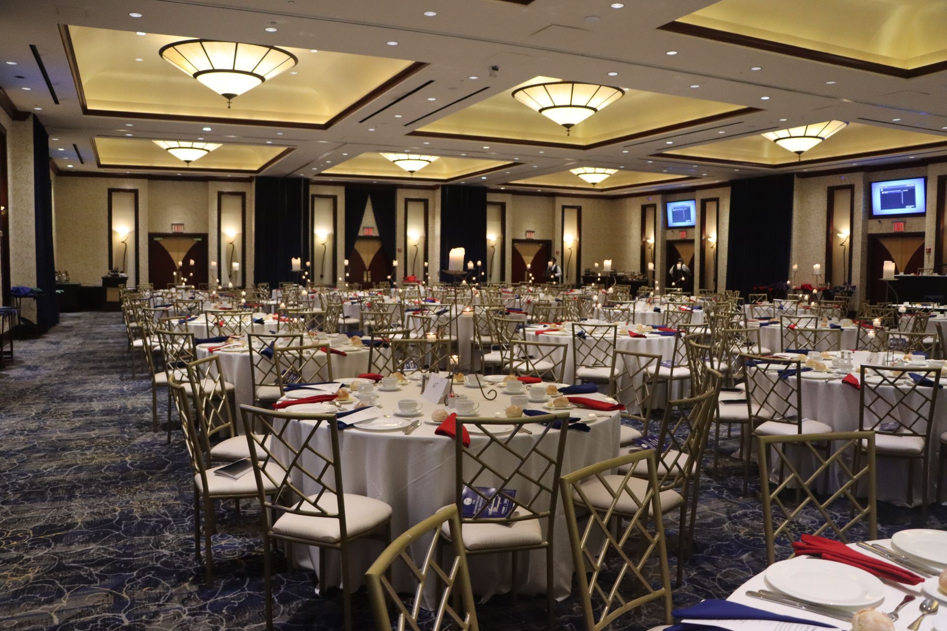 A large room with tables and chairs set up for a banquet