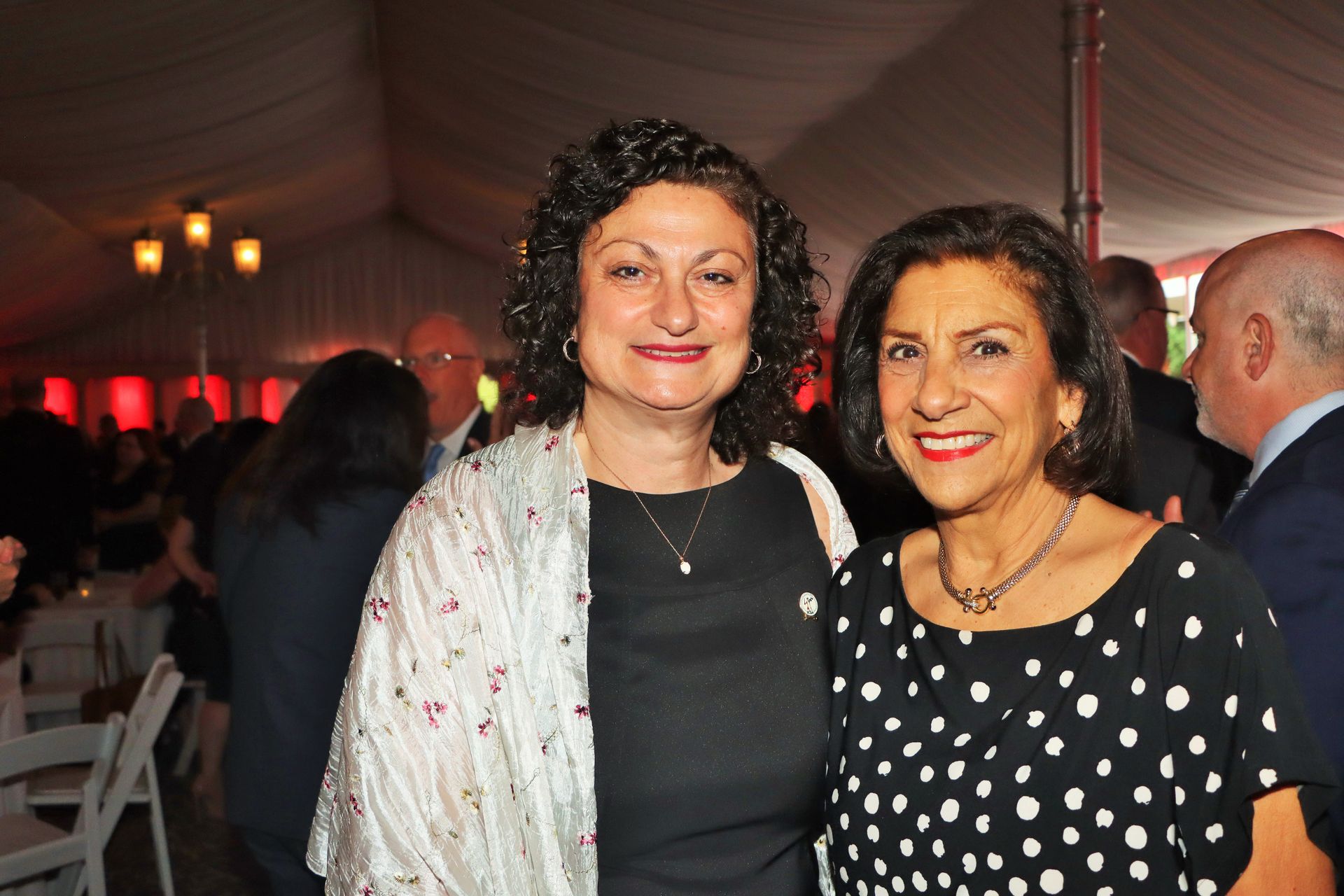 Two women are posing for a picture together at a party.
