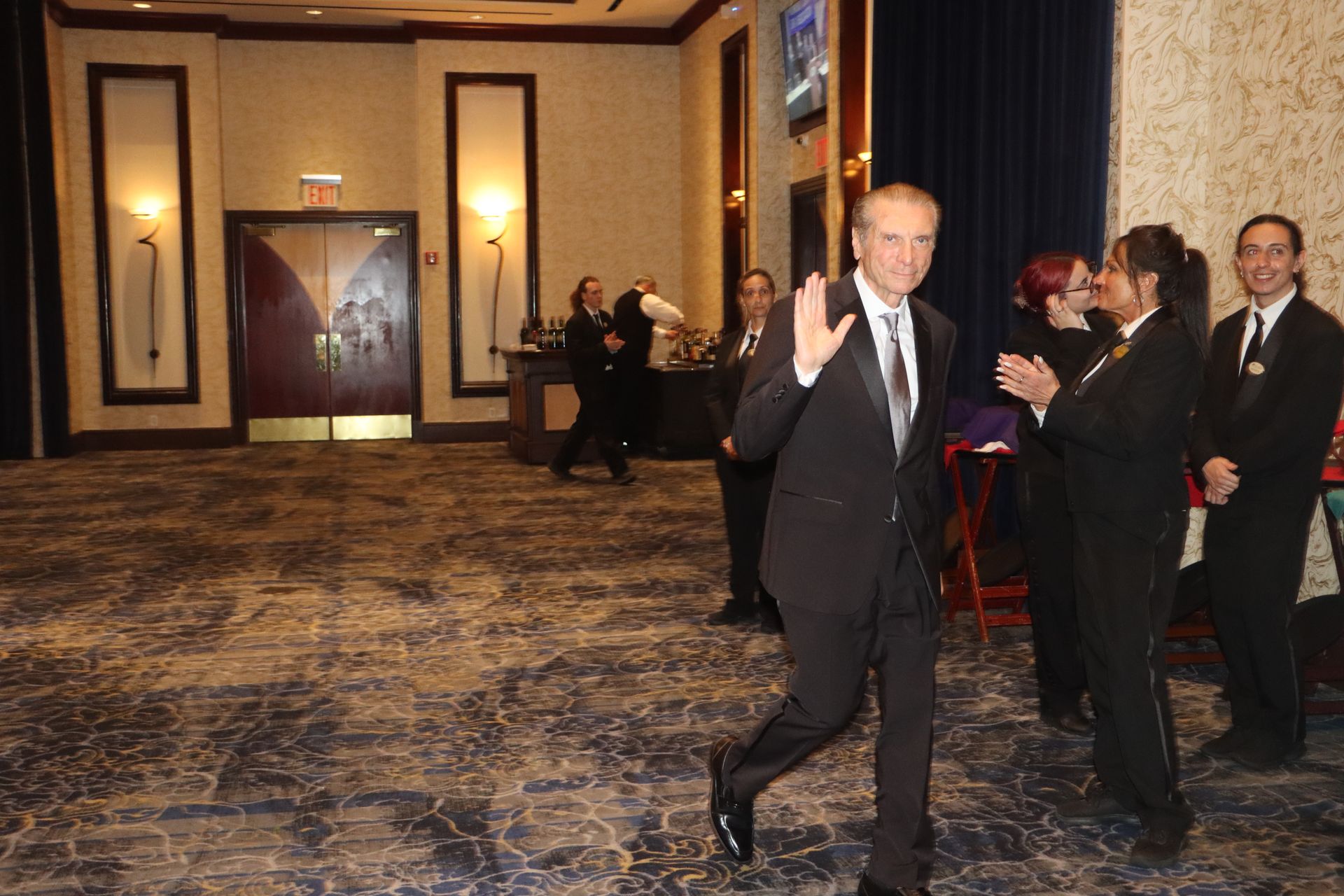 A man in a suit and tie is walking through a room