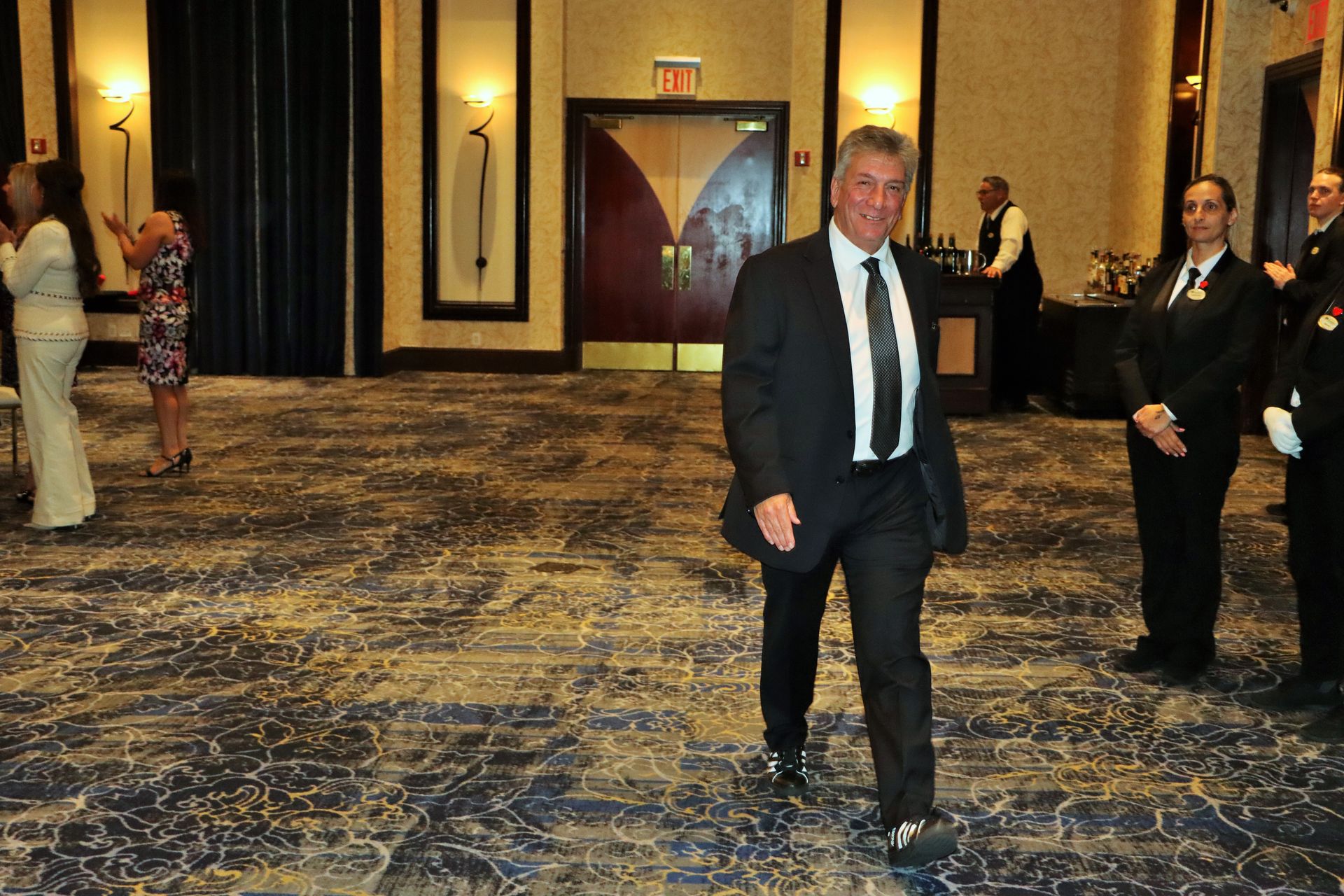 A man in a suit and tie is walking in a room