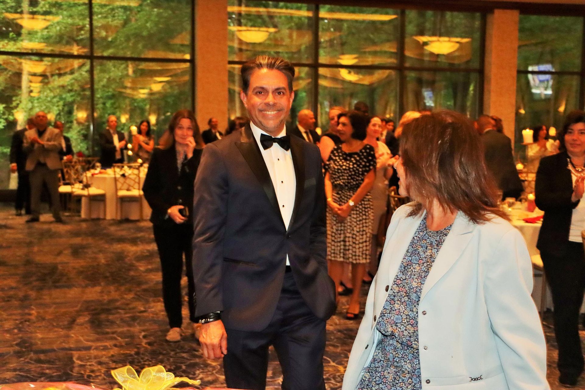 A man in a tuxedo is standing next to a woman in a blue jacket