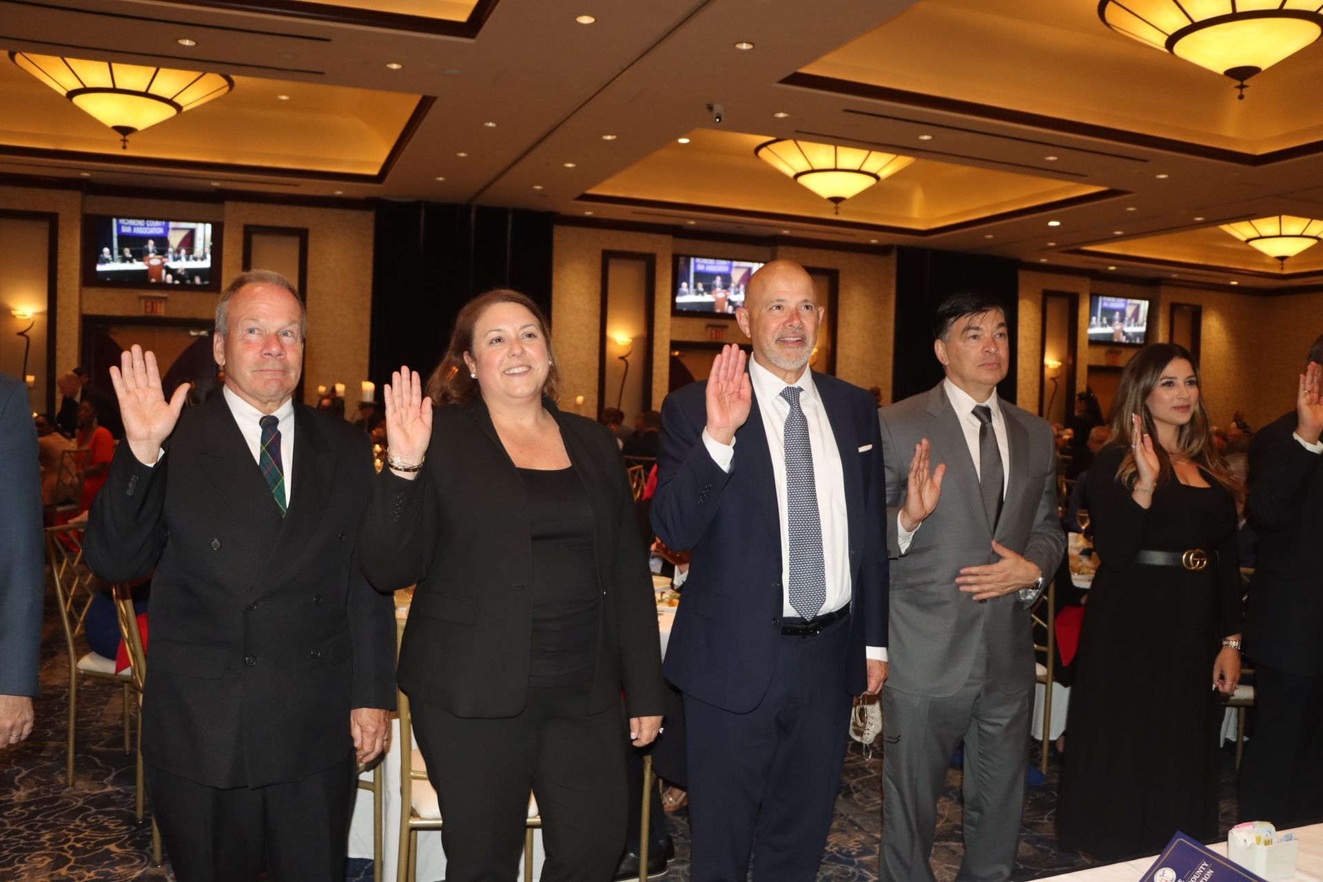 A group of people standing in a room with their hands up