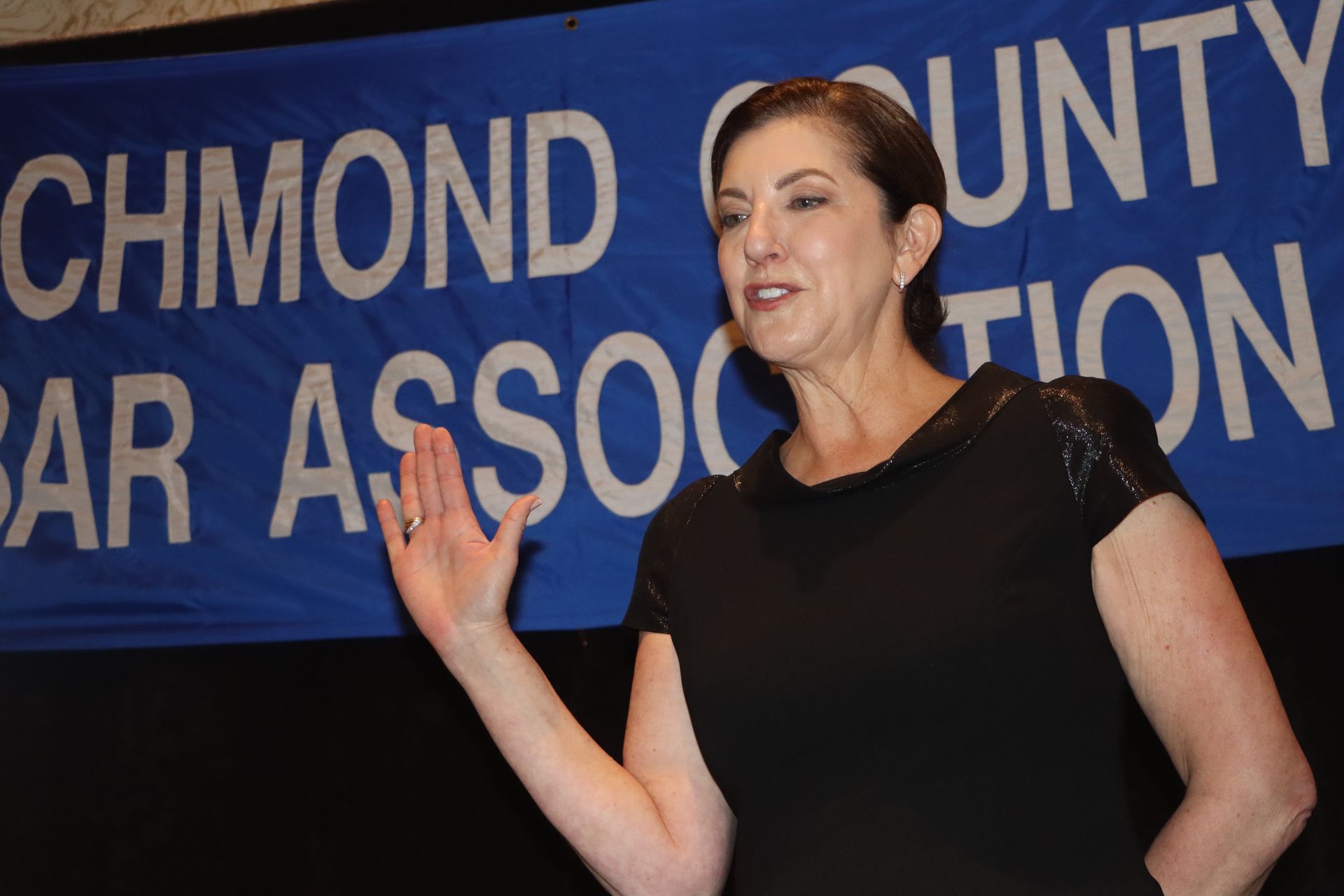 A woman stands in front of a sign that says richmond county bar association