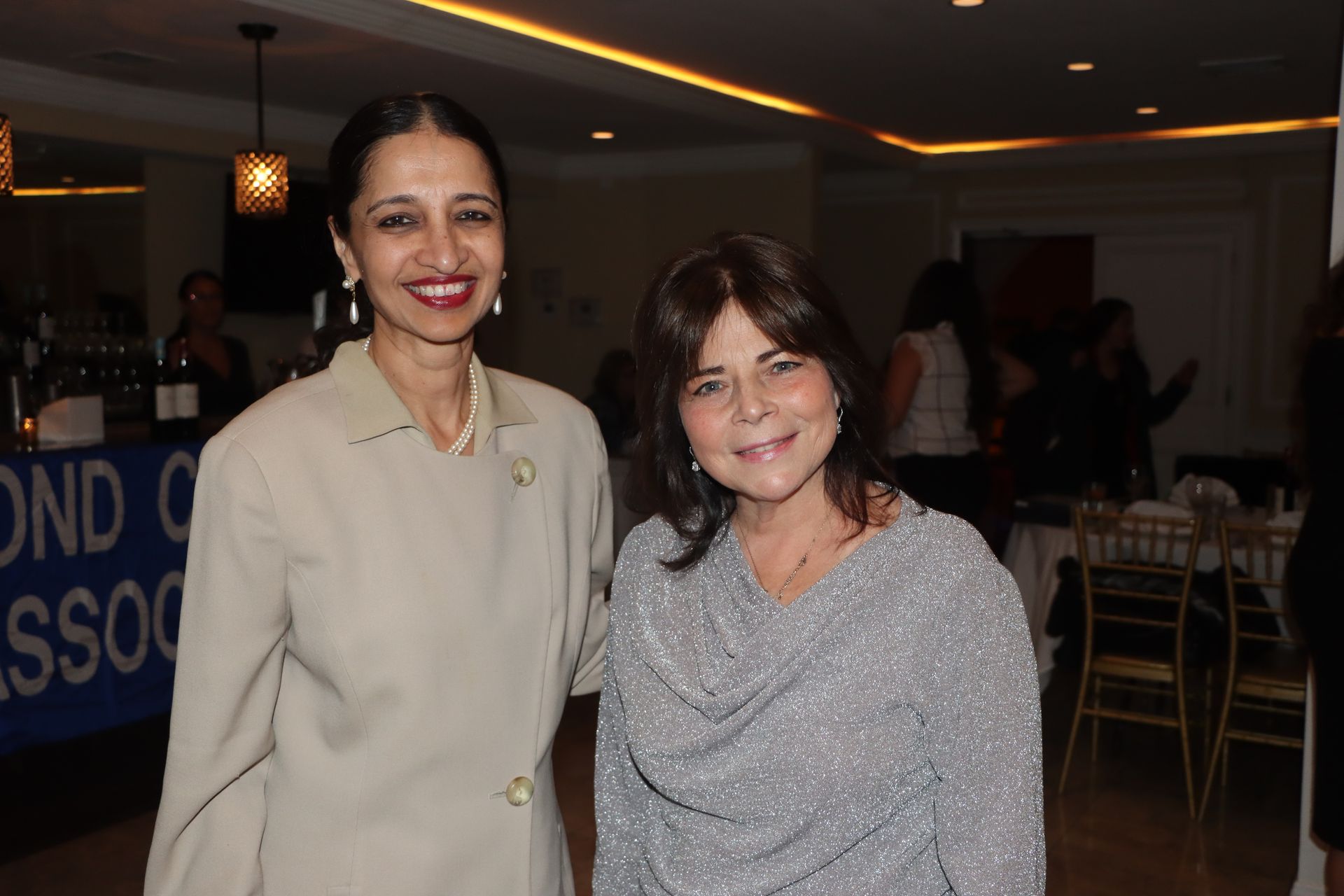 Two Women Are Posing For A Picture In Front Of A Sign That Says Bond Association — Staten Island, NY — RCBA
