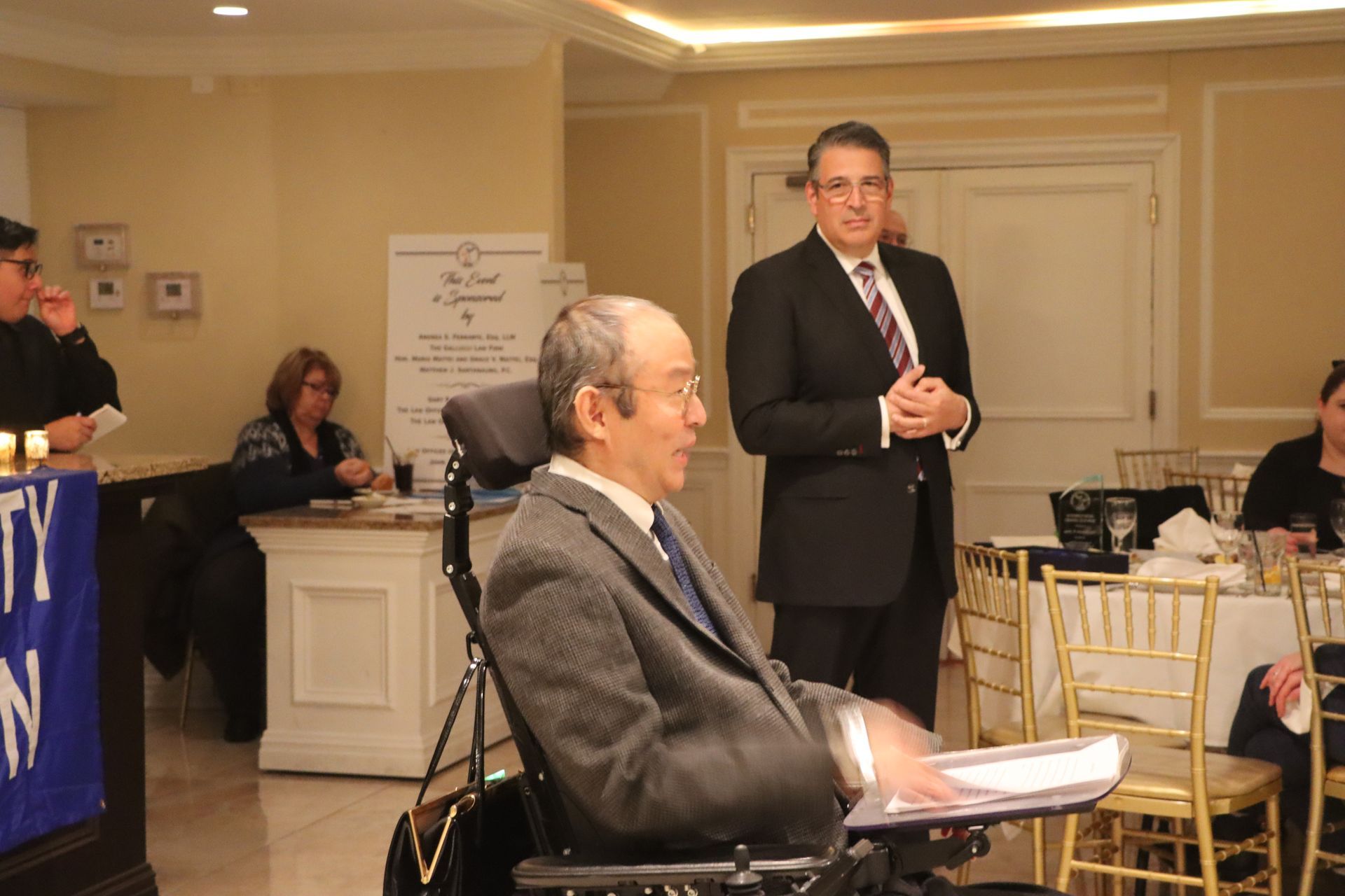 Standing Next To A Man In A Wheelchair Is A Man Dressed In A Suit — Staten Island, NY — RCBA