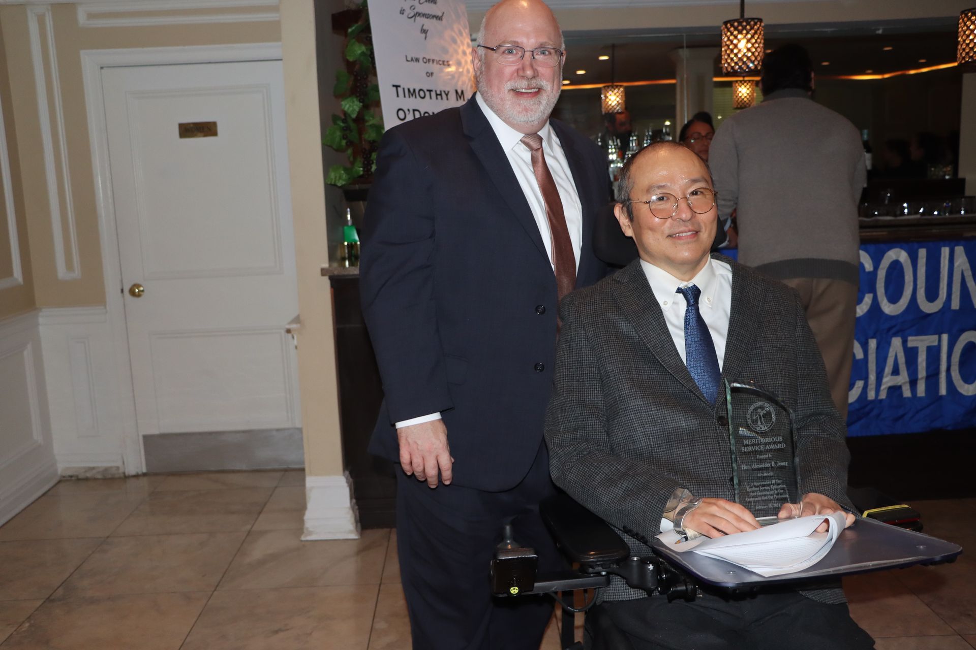 Beside A Man In A Wheelchair Is A Man Dressed In A Suit And Tie — Staten Island, NY — RCBA