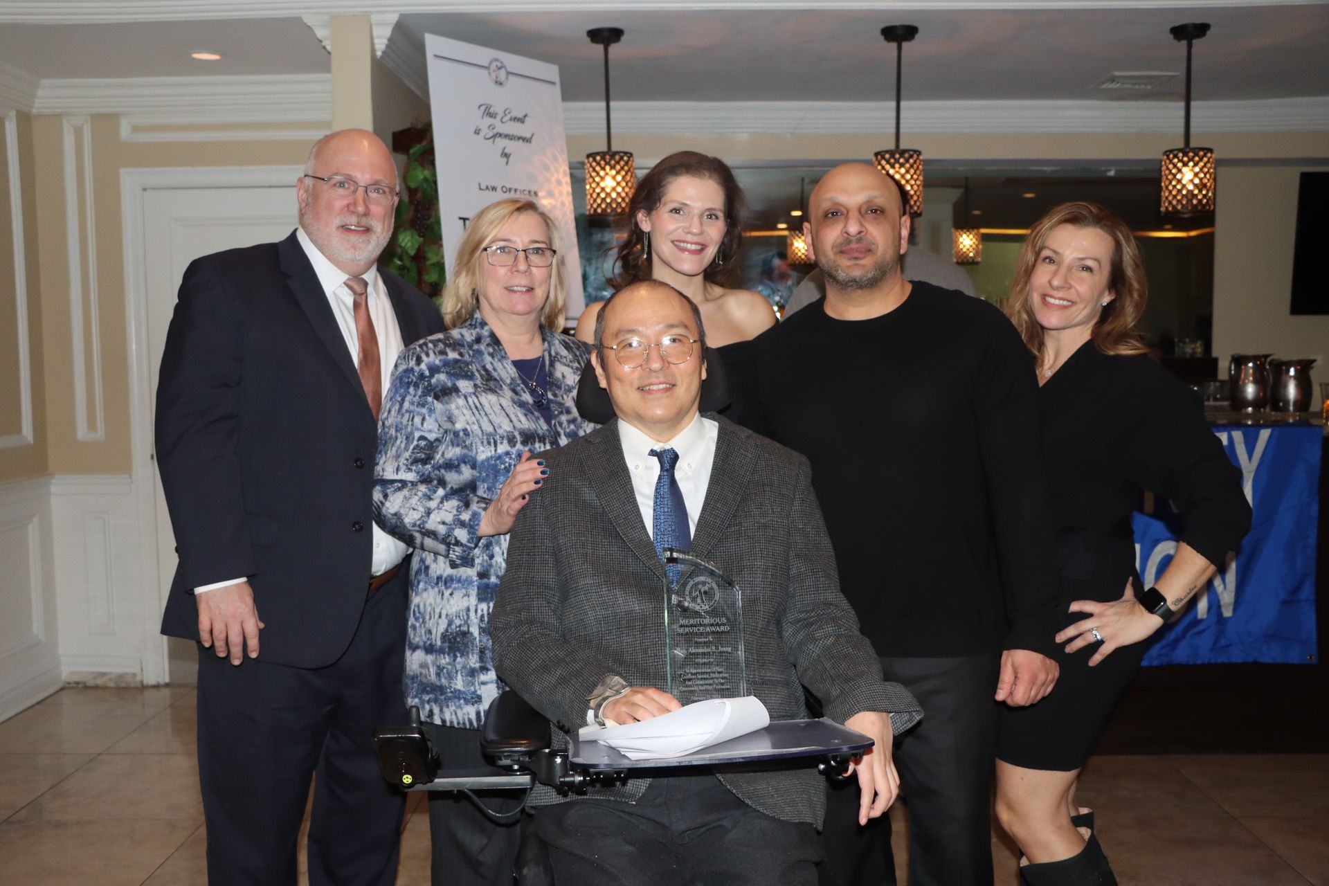 A Crowd Gathered Around A Wheelchair-Using Man — Staten Island, NY — RCBA