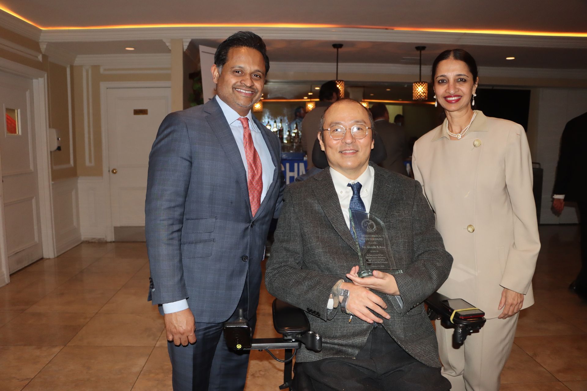 A Man In A Wheelchair Is Posing For A Picture With Two Other People — Staten Island, NY — RCBA
