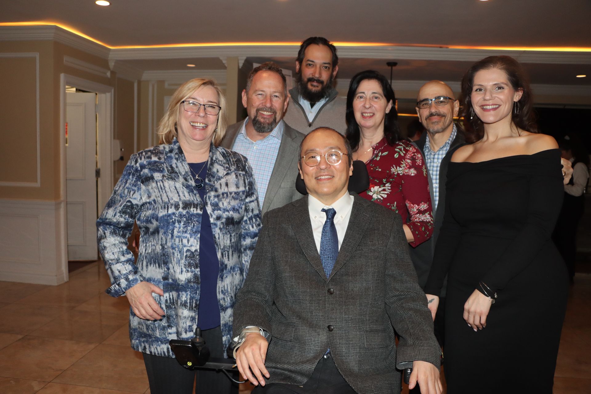 A Group Of People Are Posing For A Picture With A Man In A Wheelchair — Staten Island, NY — RCBA