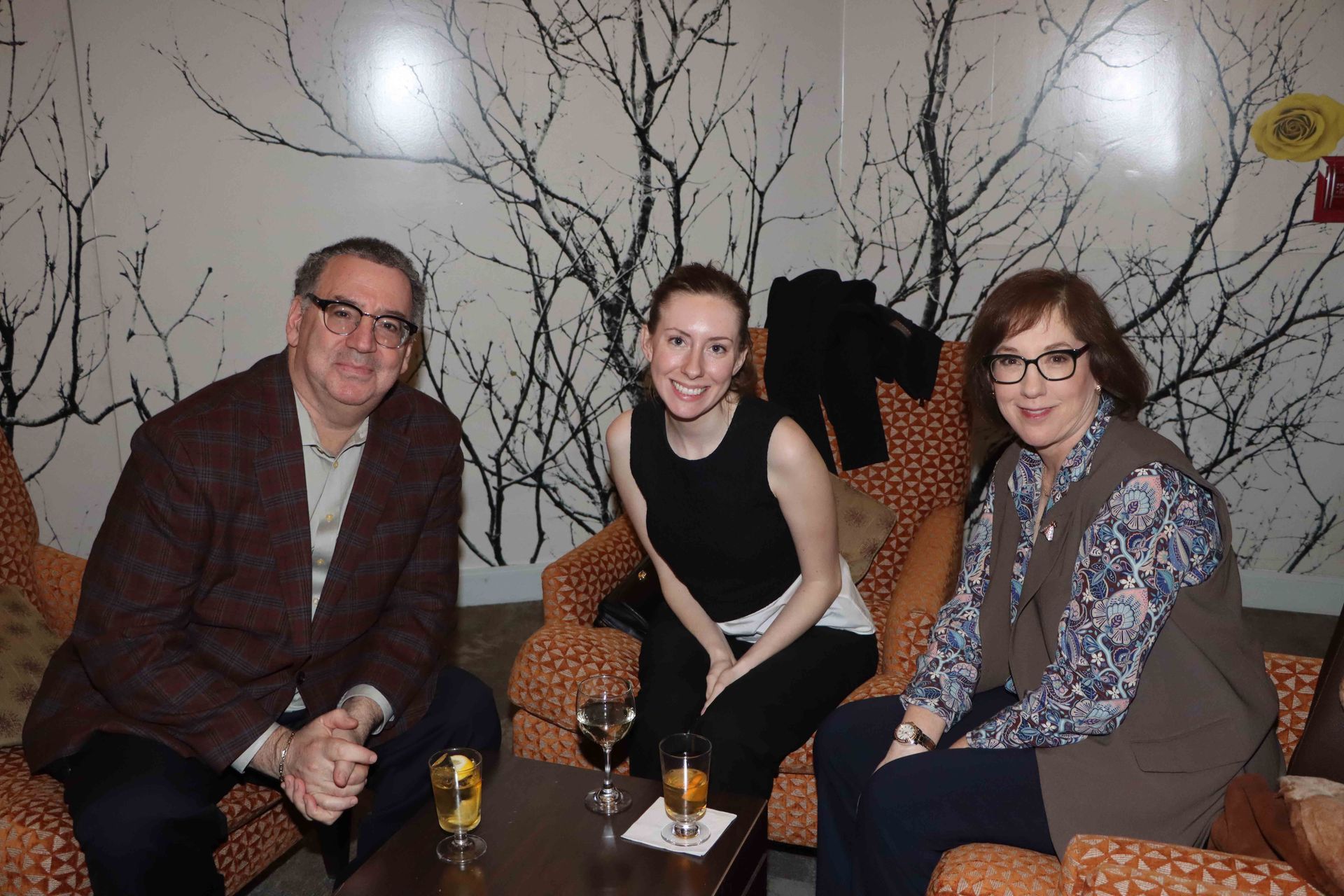 A Man And Two Women Are Sitting In Chairs With Wine Glasses On A Table | Staten Island, NY | RCBA