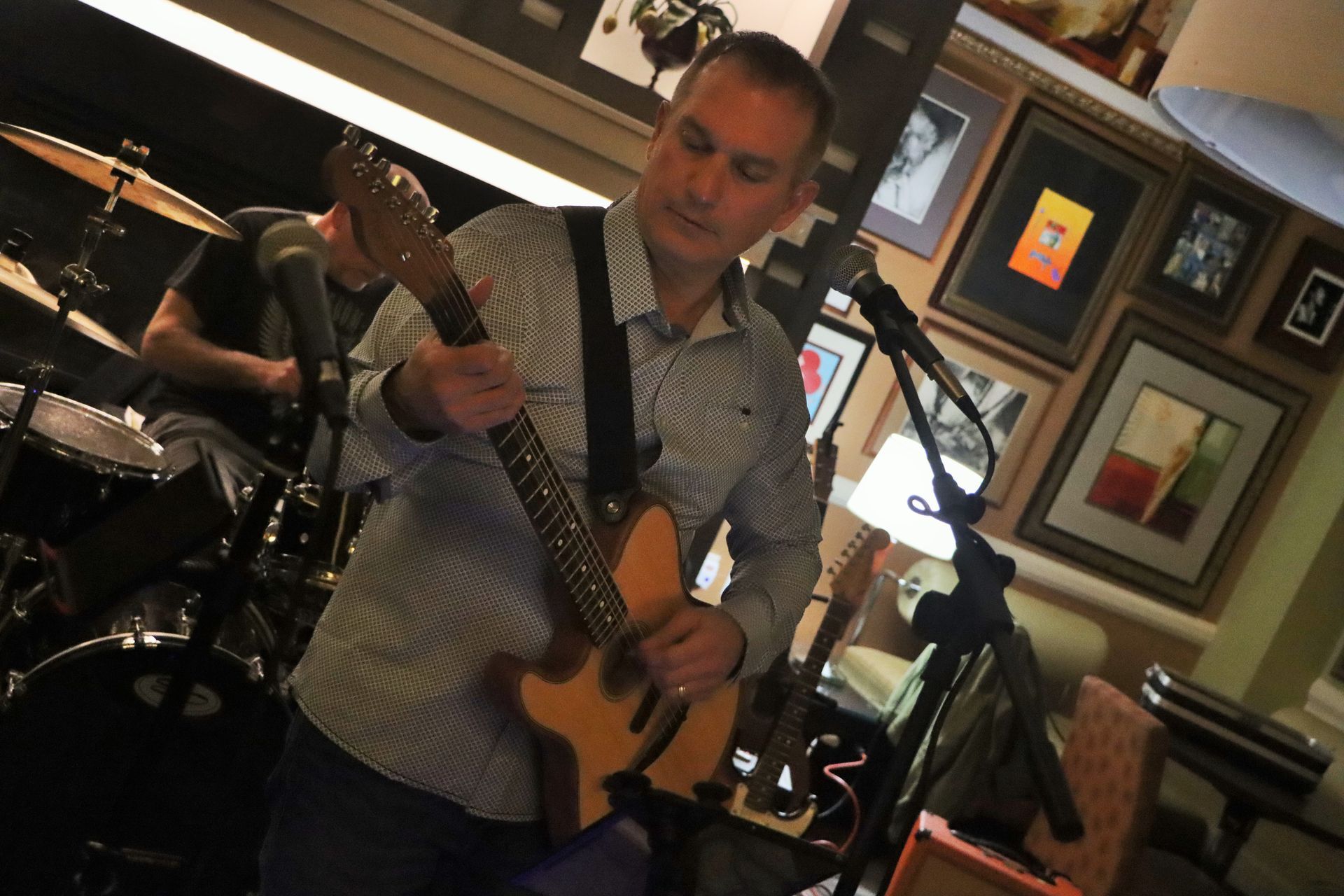 A Man Playing a Guitar in Front of a Drum Set | Staten Island, NY | RCBA