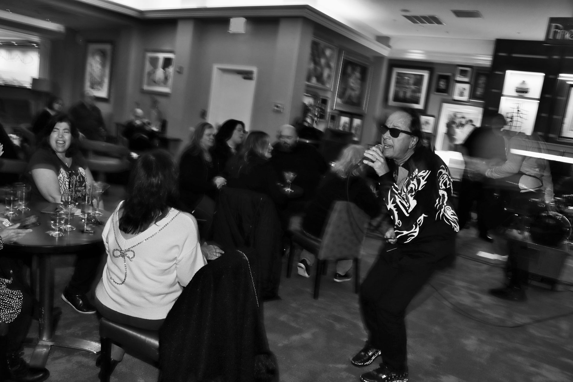 A Black and White Photo of a Man Singing into a Microphone in a Restaurant — Staten Island, NY — RICHMOND COUNTY BAR ASSOCIATION