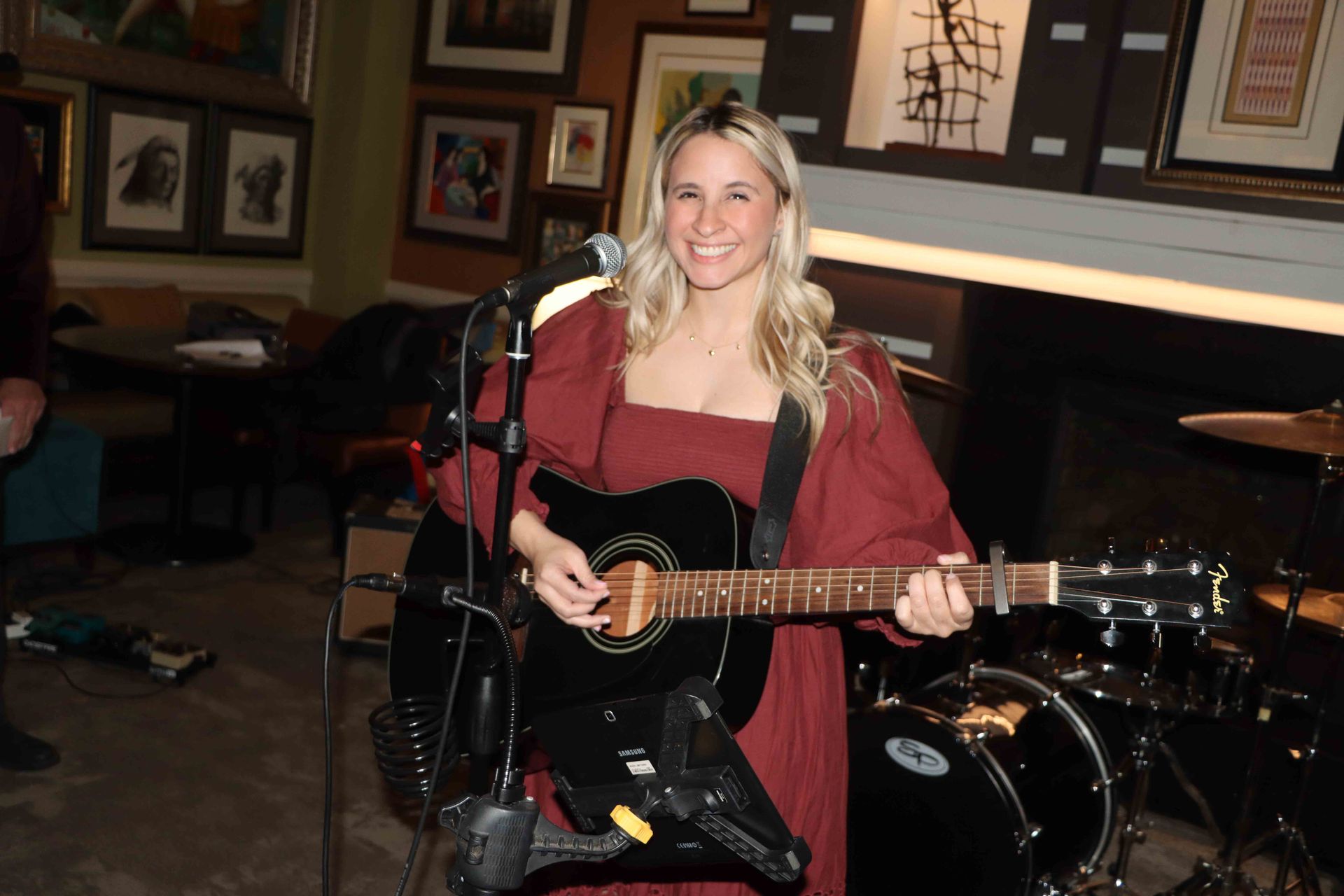A Woman In A Red Dress Is Playing A Guitar And Singing Into A Microphone | Staten Island, NY | RCBA