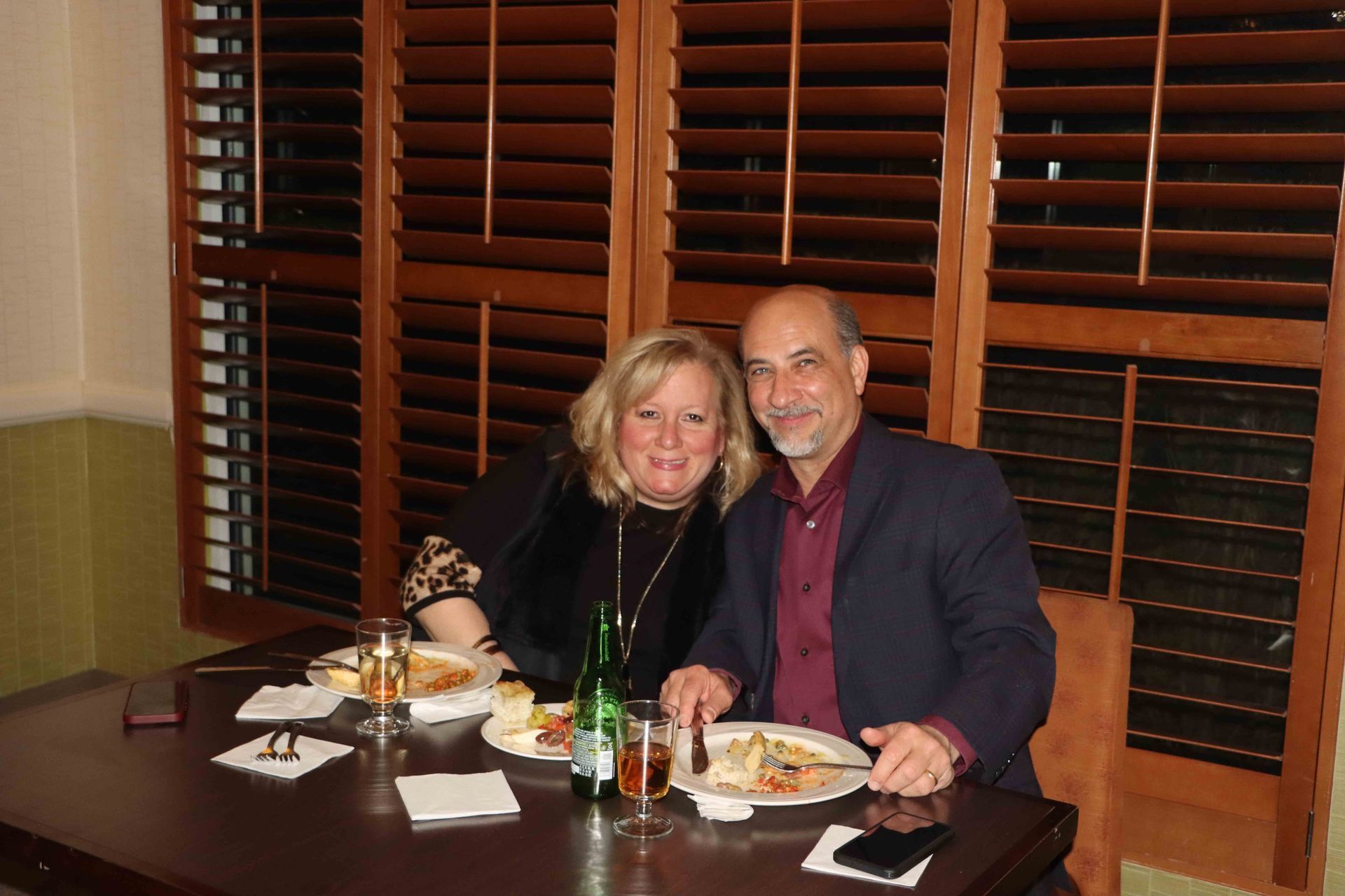 A Man And A Woman Are Sitting At A Table With Plates Of Food And Drinks | Staten Island, NY | RCBA