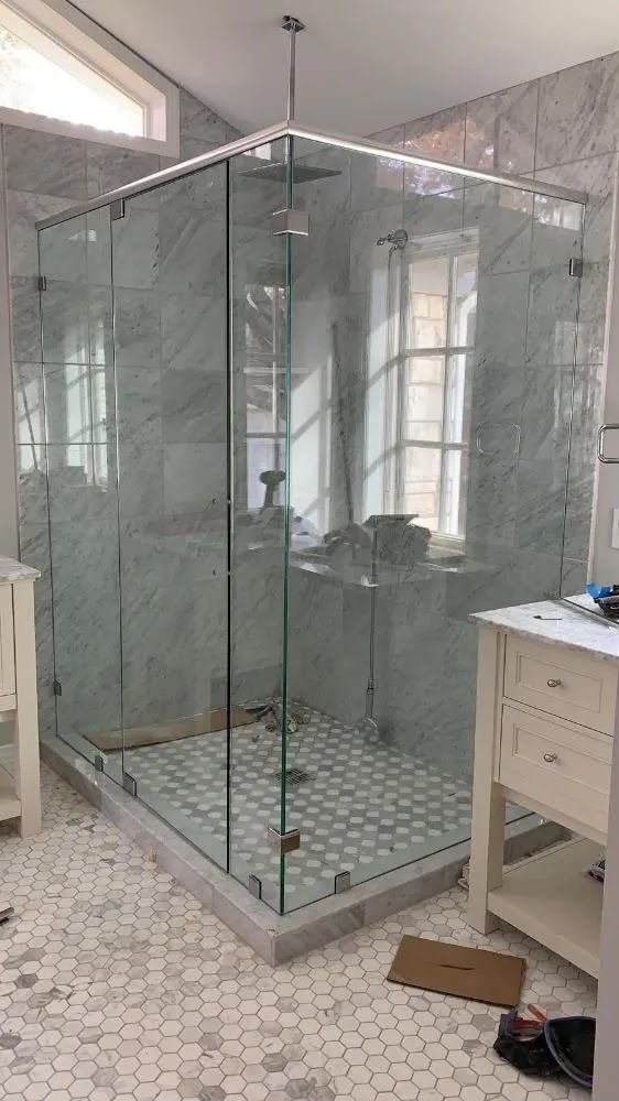 A bathroom with a walk in shower and a sink.