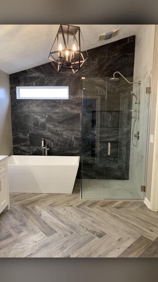 A bathroom with a bathtub and a walk in shower.