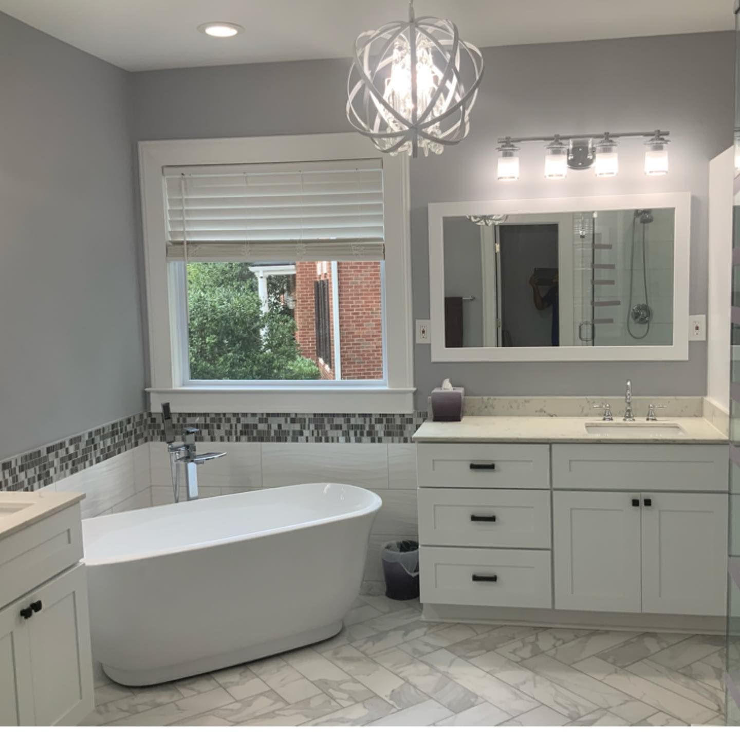 A bathroom with a tub a sink and a mirror