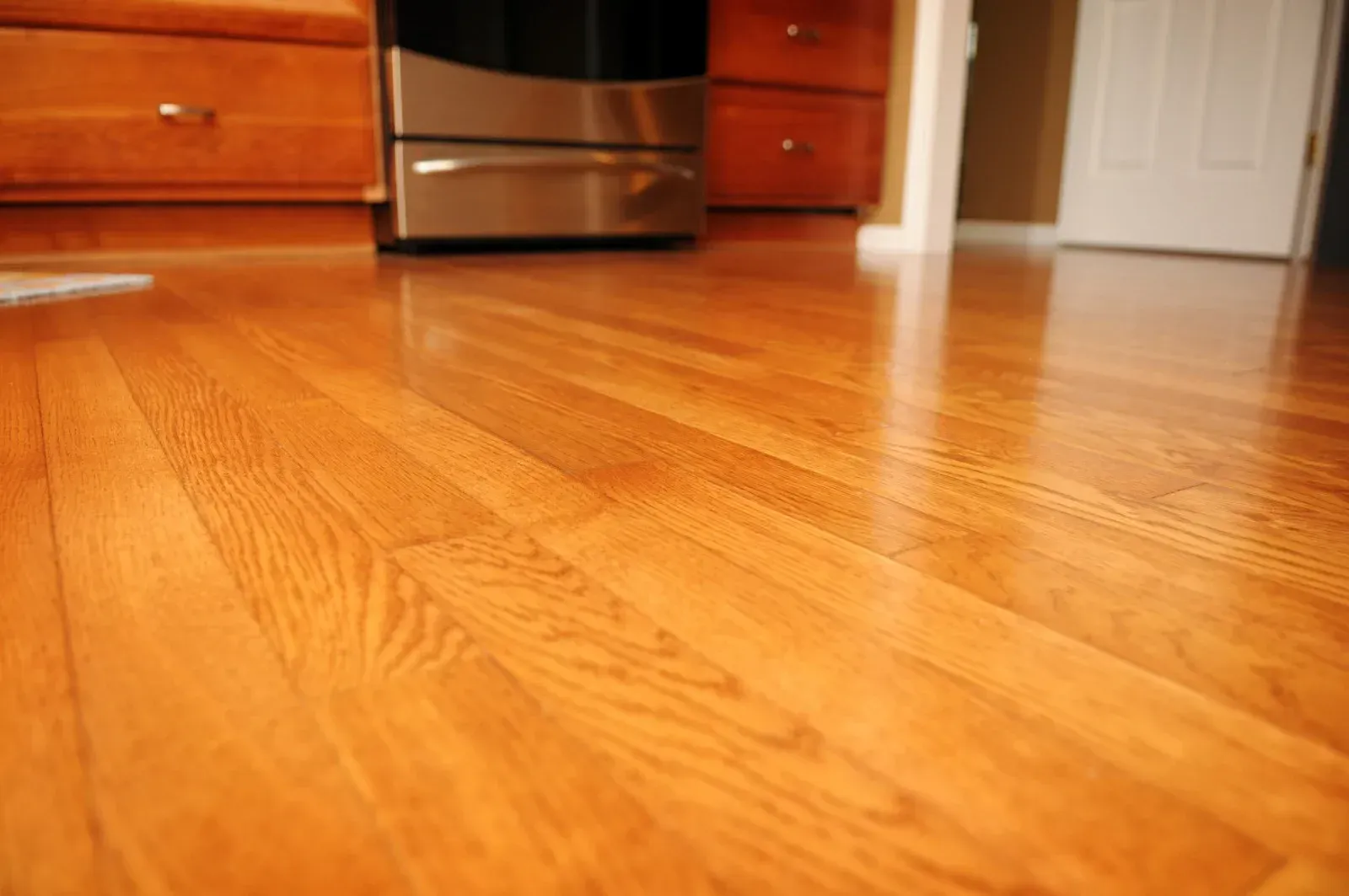 A kitchen with hardwood floors and a stainless steel appliance