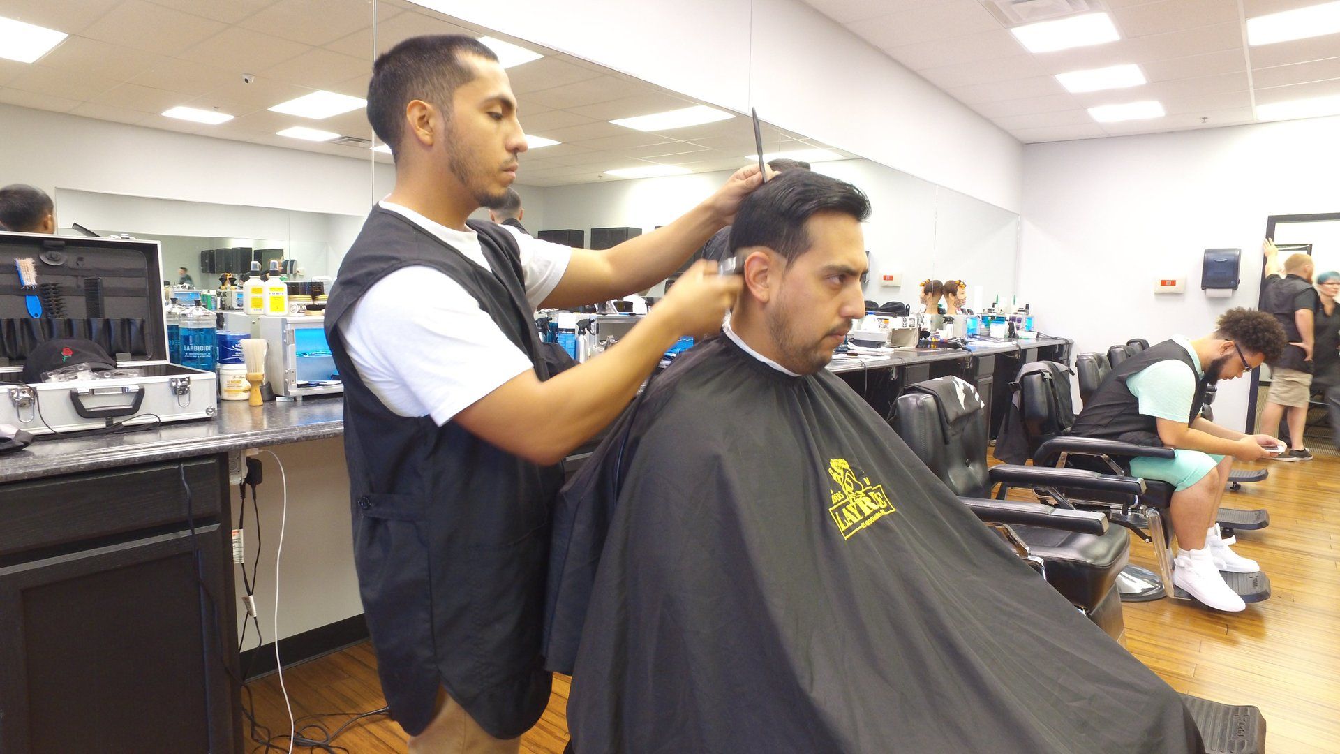 A man is getting his hair cut by a barber in a barber shop.
