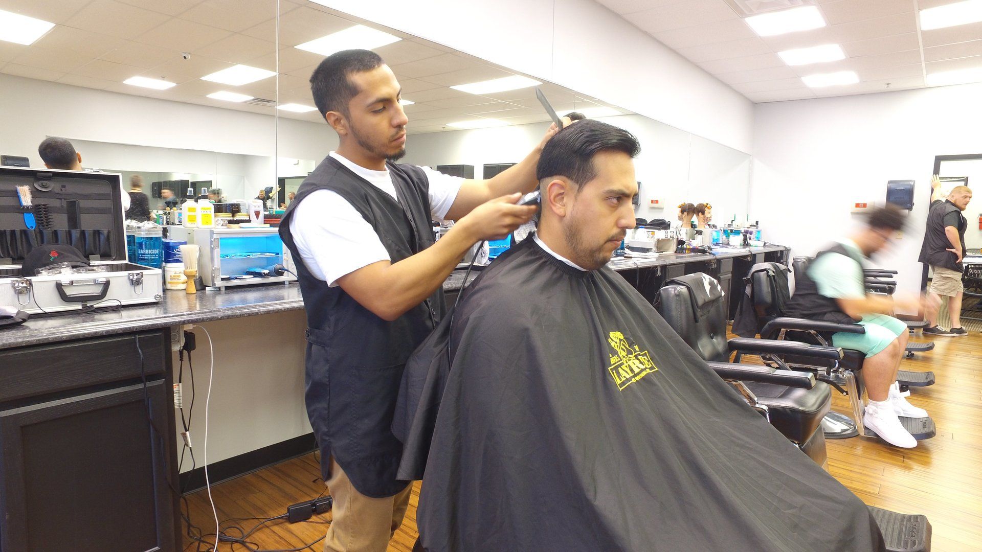 A man is getting his hair cut by a barber in a barber shop.