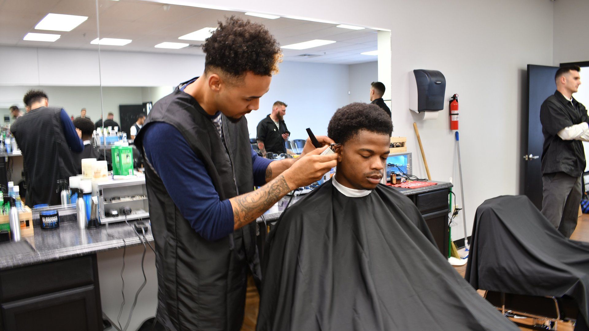 A man is getting his hair cut by a barber in a barber shop.