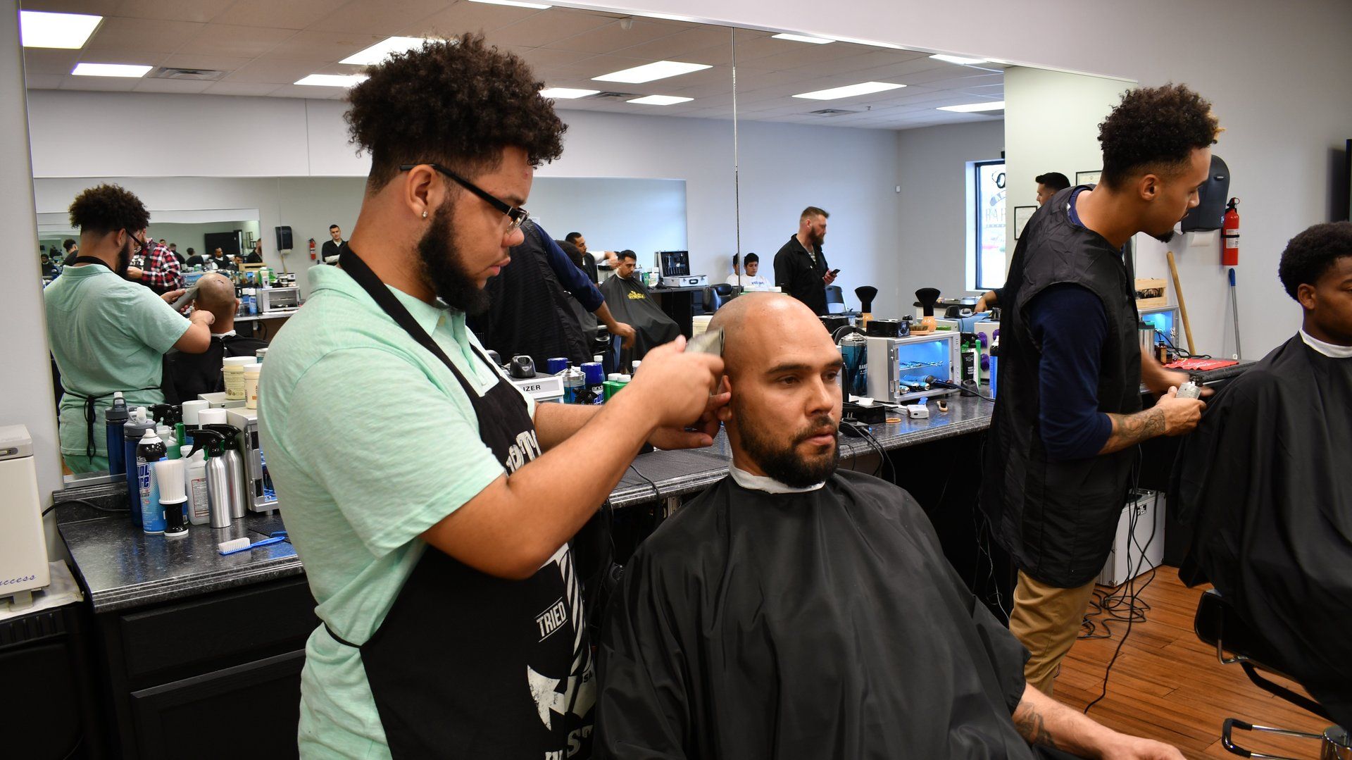 A man is getting his hair cut at a barber shop.