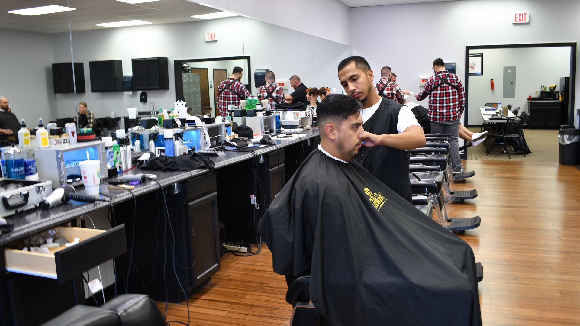 A man is getting his hair cut at a barber shop.
