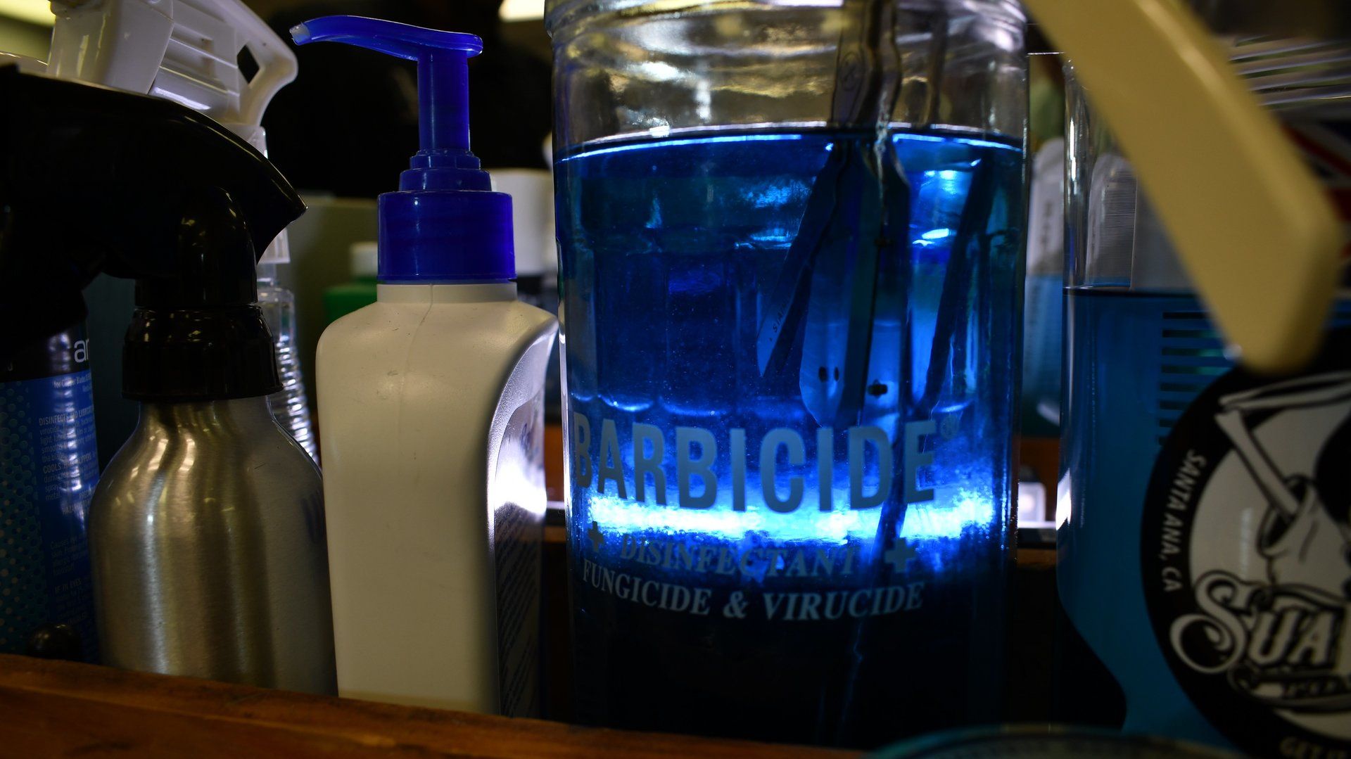 A glass filled with blue liquid that says ' arbicide ' on it