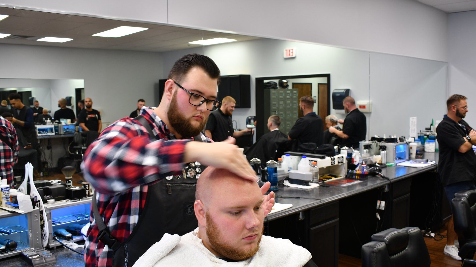 A man is getting his hair cut by a barber in a barber shop.