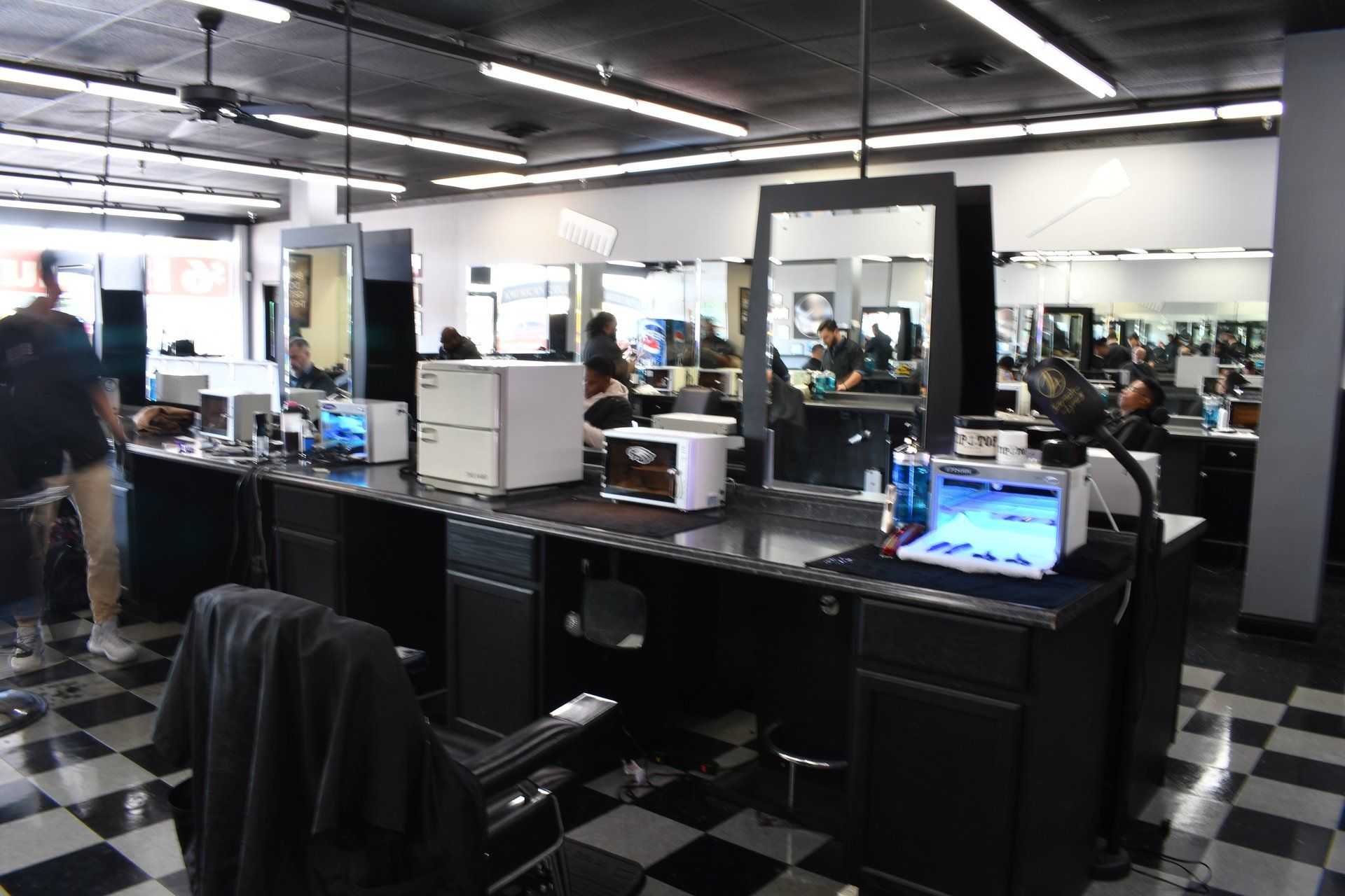 A barber shop with a checkered floor and a lot of chairs