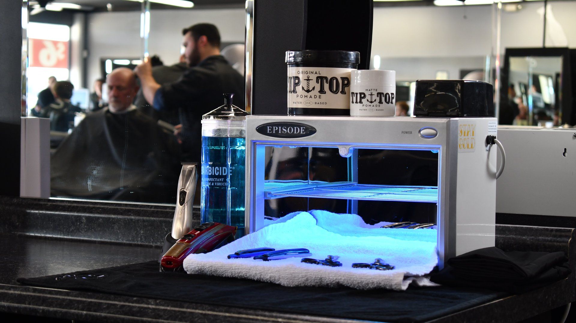 A man is getting his hair cut in a barber shop.