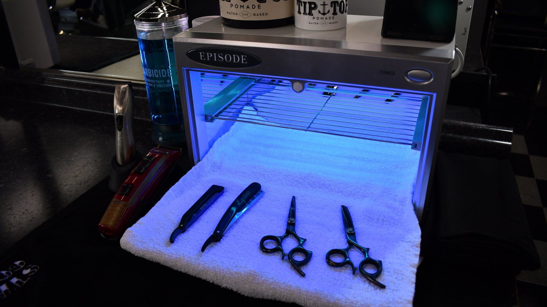 A pair of scissors sitting on top of a towel under a blue light.