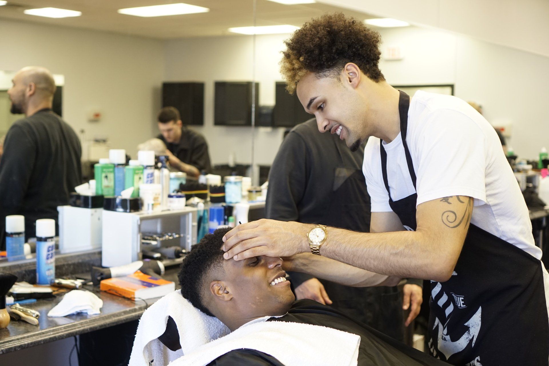 A man is getting his hair cut by a barber in a barber shop.