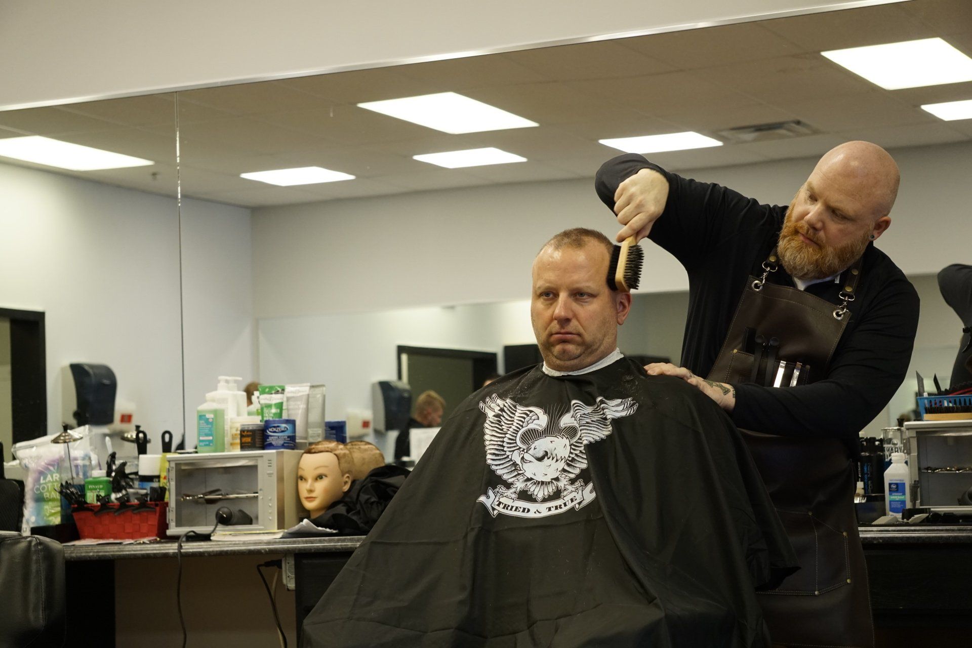A man is getting his hair cut by a barber in a barber shop.