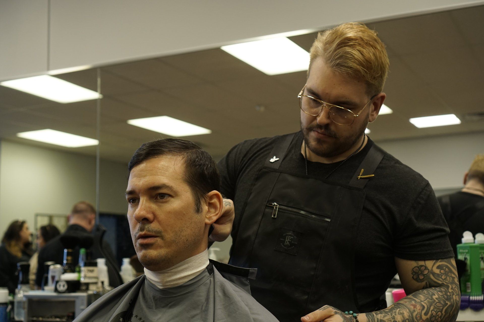 A man is getting his hair cut by a barber in a barber shop.