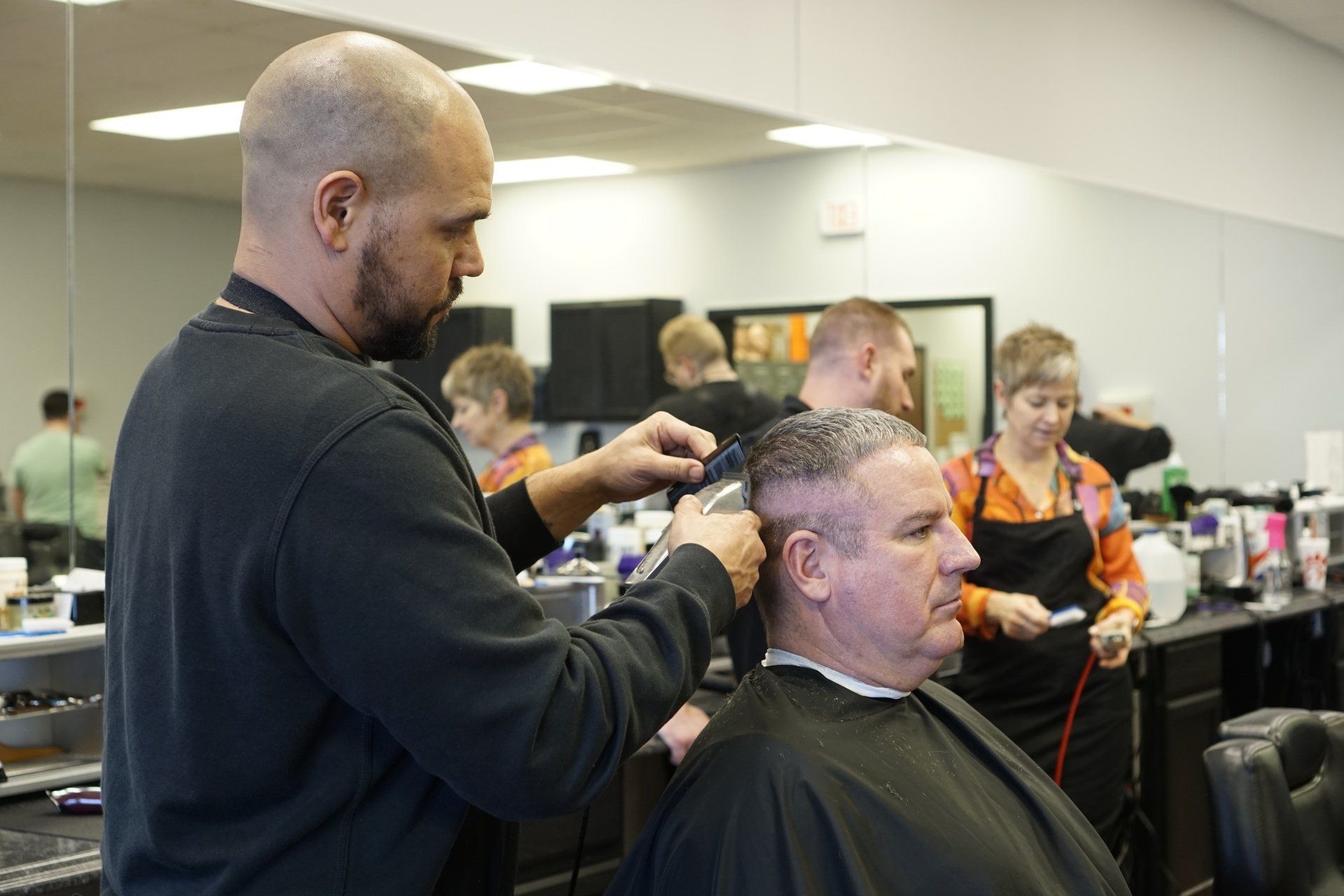 A man is getting his hair cut at a barber shop.
