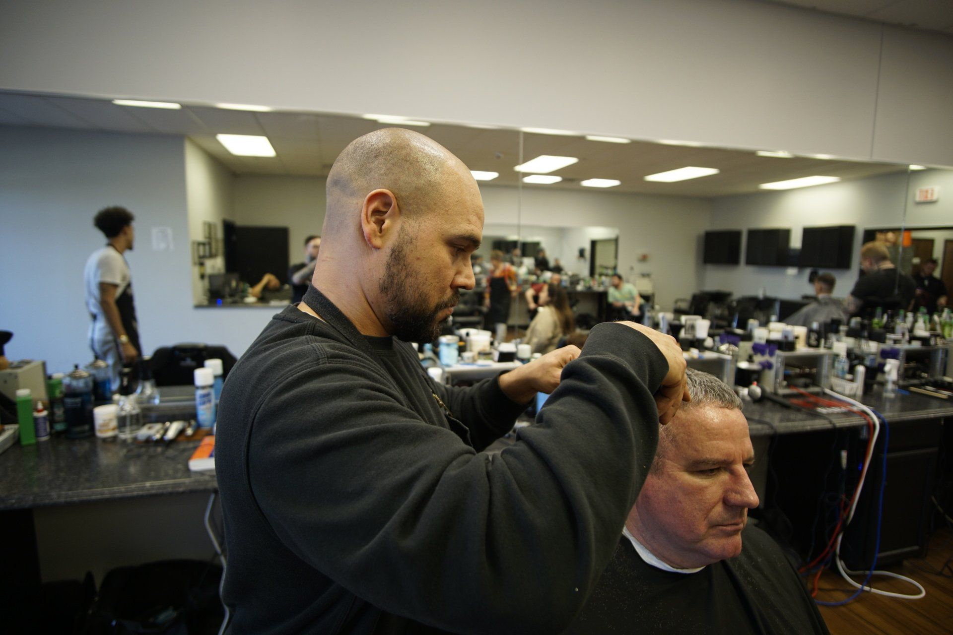 A man is getting his hair cut by a barber in a barber shop.