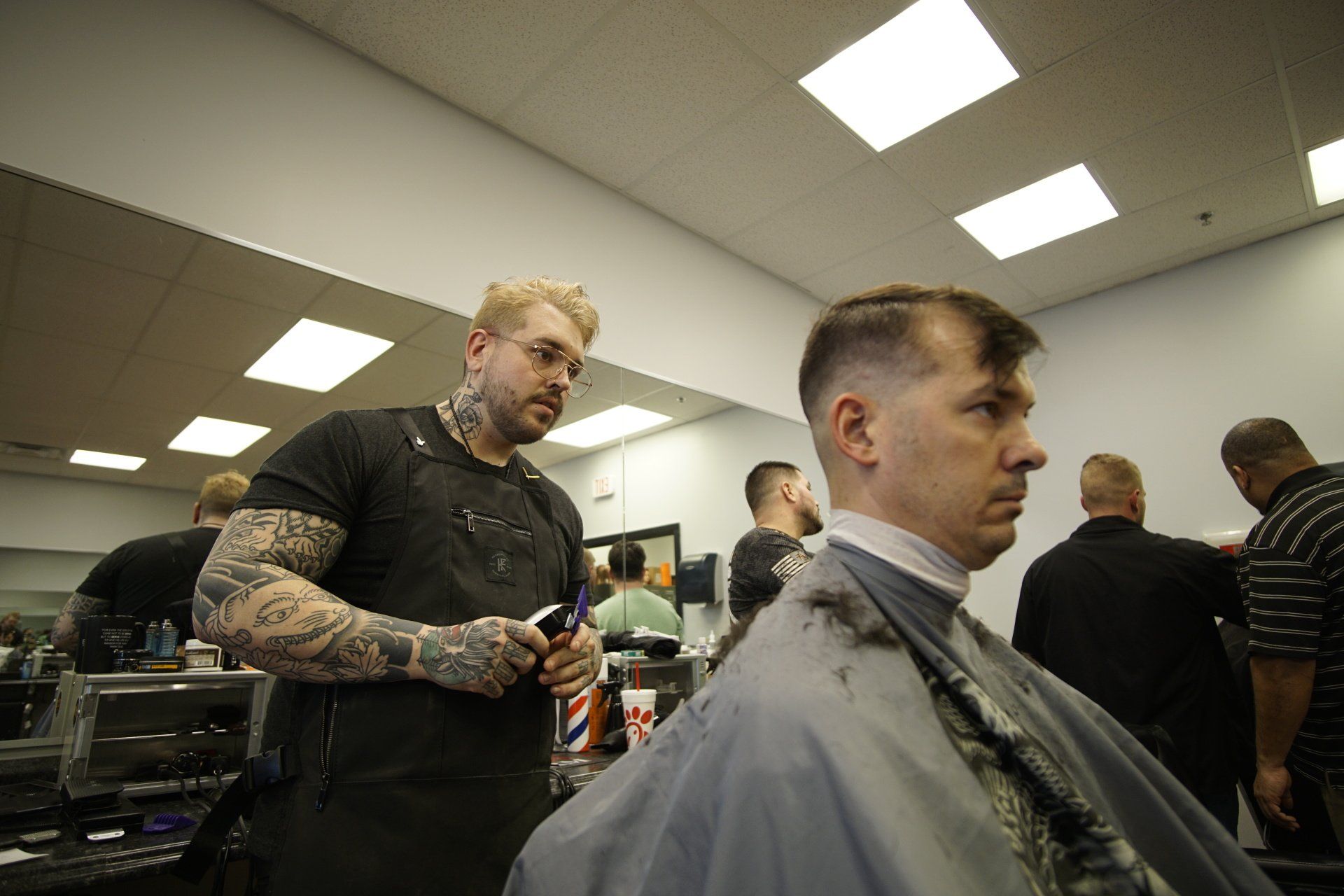 A man is getting his hair cut by a barber in a barber shop.